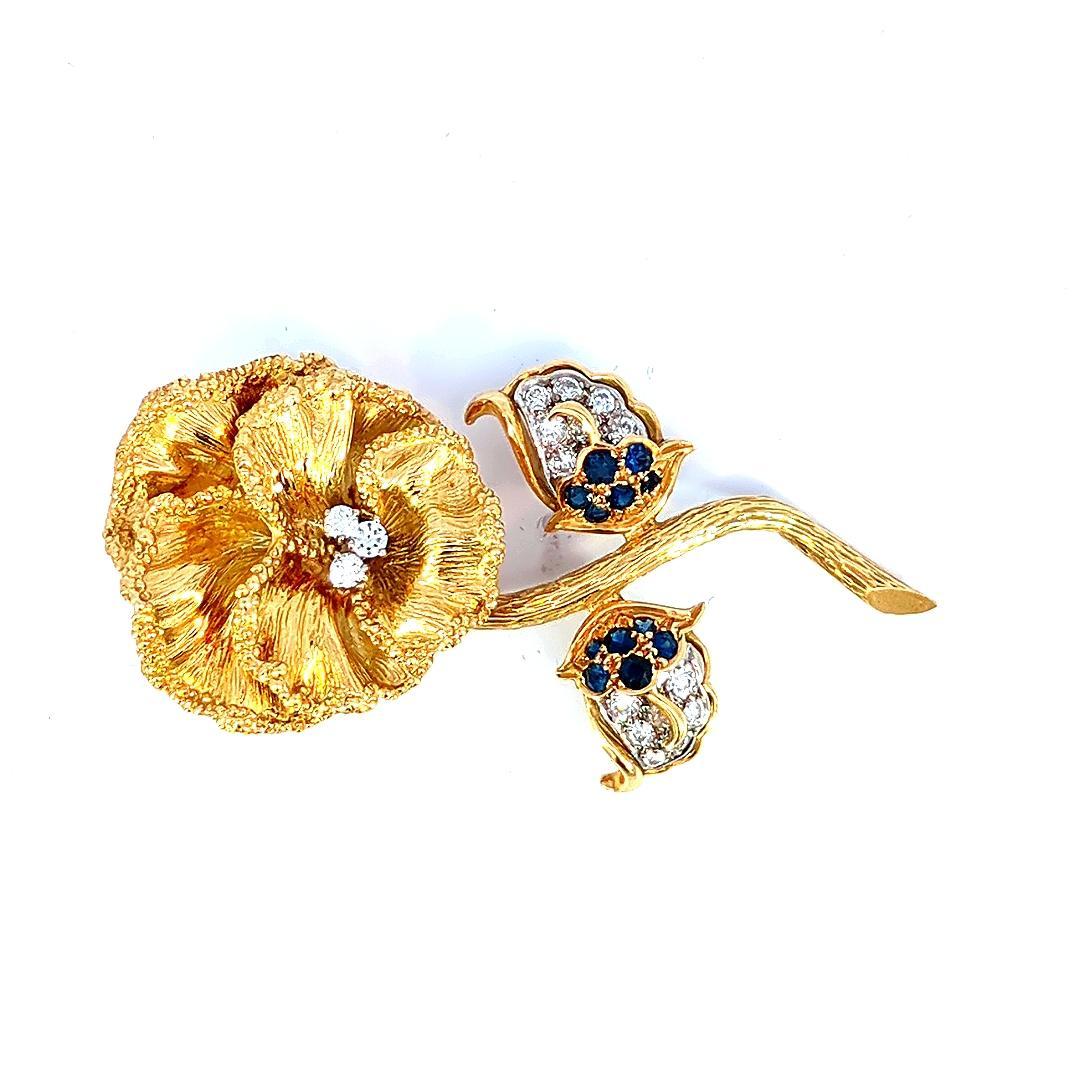 Introducing our exquisite Blue Sapphire and Diamond Flower Pin, a finely crafted piece of jewelry that marries the timeless elegance of blue sapphires with the brilliance of diamonds, all set in lustrous 18K yellow gold. This flower pin is a true