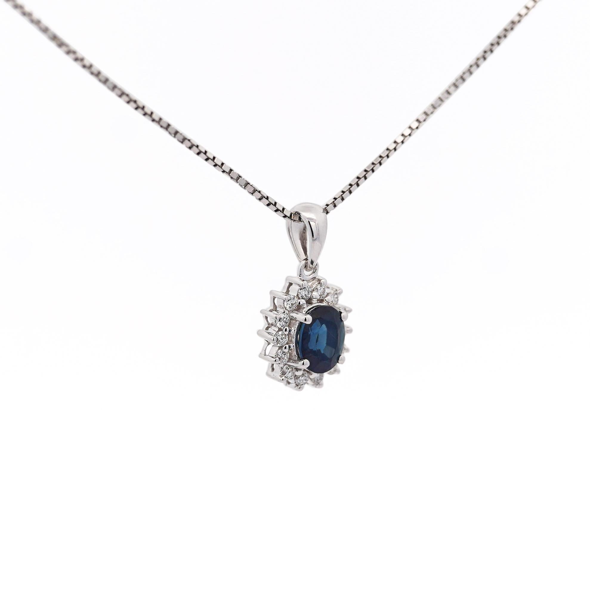 Pendentif classique en saphir bleu, réalisé en or blanc massif 14K, mettant en valeur un saphir naturel de 1,08 carat de taille ovale, élégamment rehaussé d'un halo de diamants de taille ronde d'un total de 0,17 carat. Conçu pour être porté au