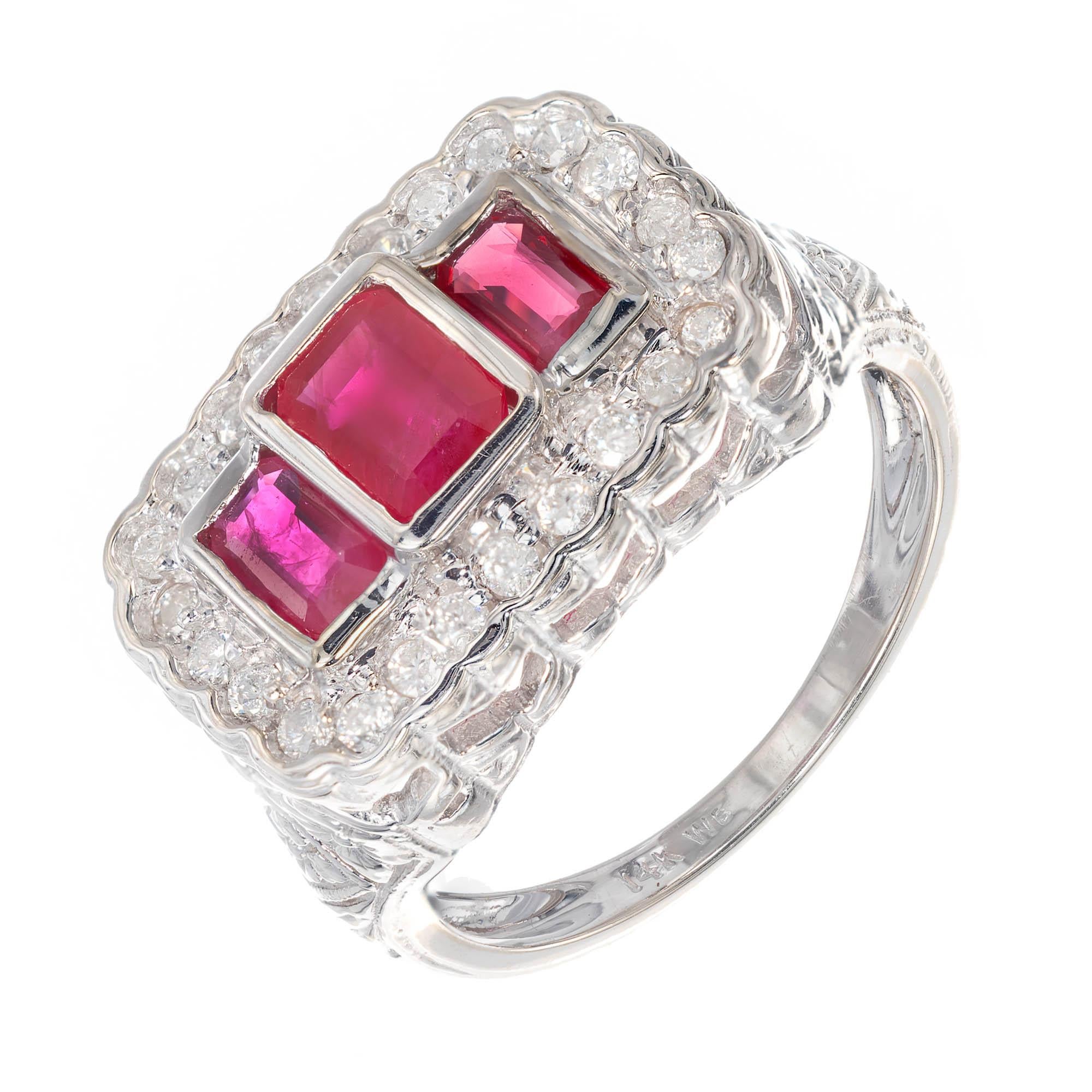14k White gold vintage ruby and diamond cocktail ring. Larger octagonal step cut ruby bezel set in the center of two smaller octagonal rubies bezel set with a rectangular halo of round diamonds around the shank of ring with cut out heart filigree