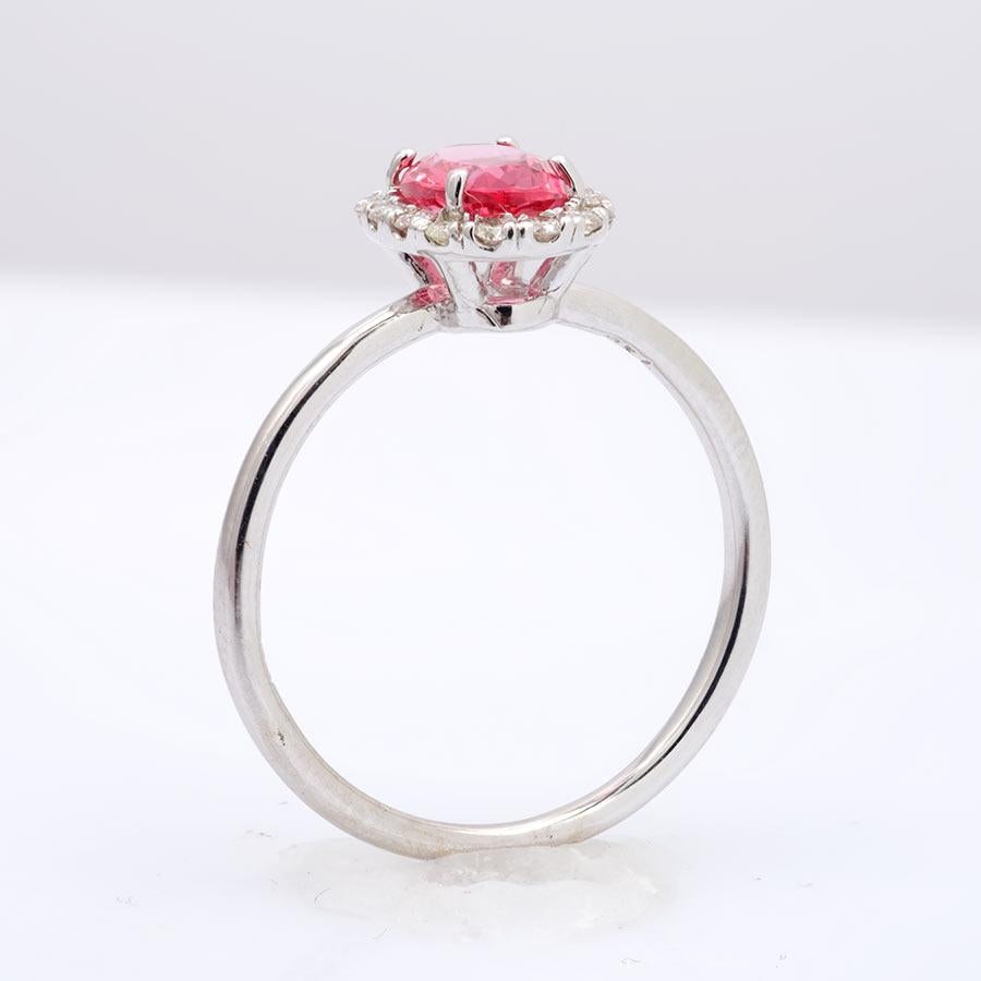 Both delicate and elegant, this reddish pink spinel that has been mined in Tanzania is the epitome of beauty. Perfect to present as an engagement ring, this ring is both subtle yet has just the right burst of color. Set in 14K white gold, you will