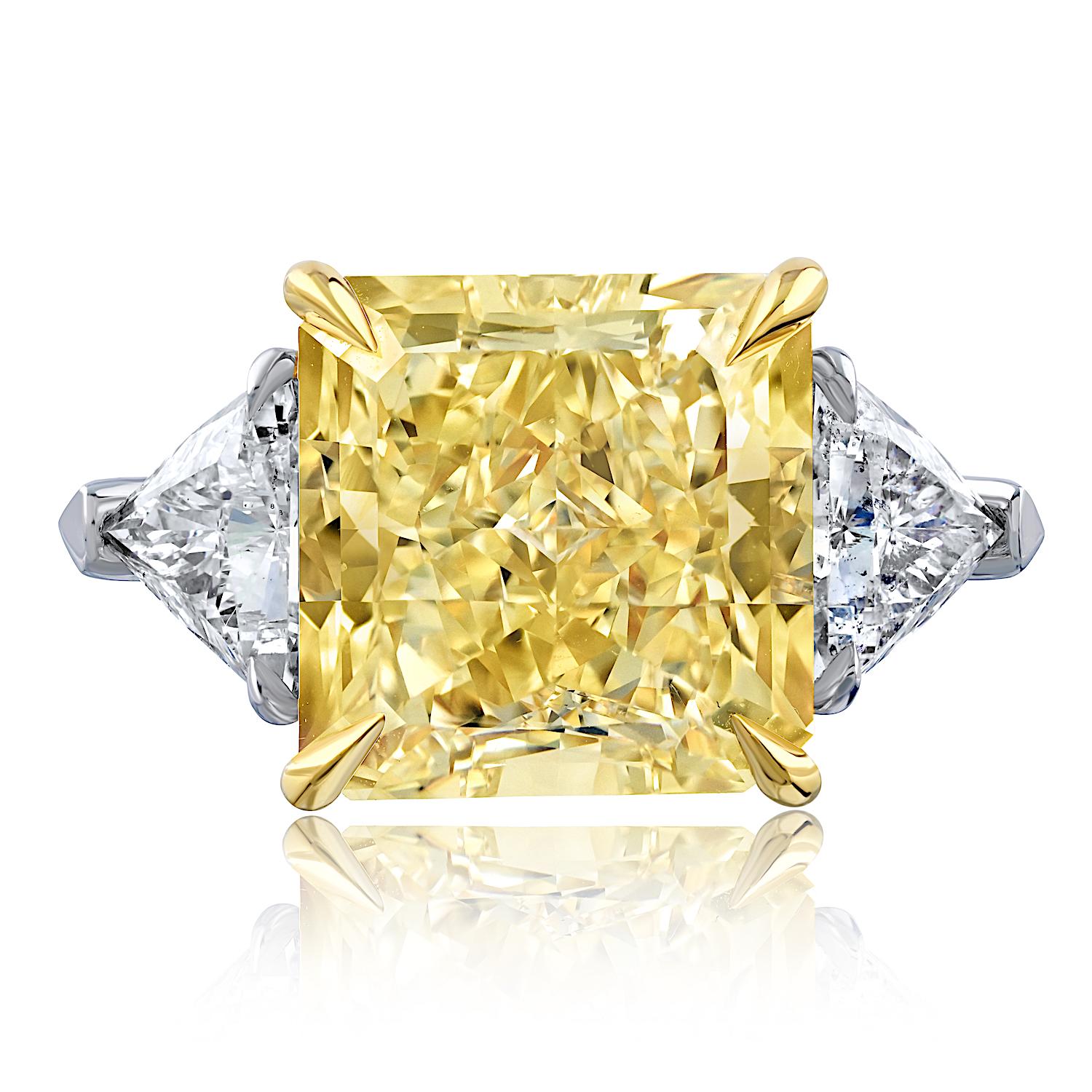 A truly exceptional creation, this three-stone diamond engagement ring showcases timeless sophistication and rare beauty. At its heart lies a magnificent 10.81-carat Radiant Cut diamond, certified by GIA, displaying a rich Fancy Yellow hue with VS2