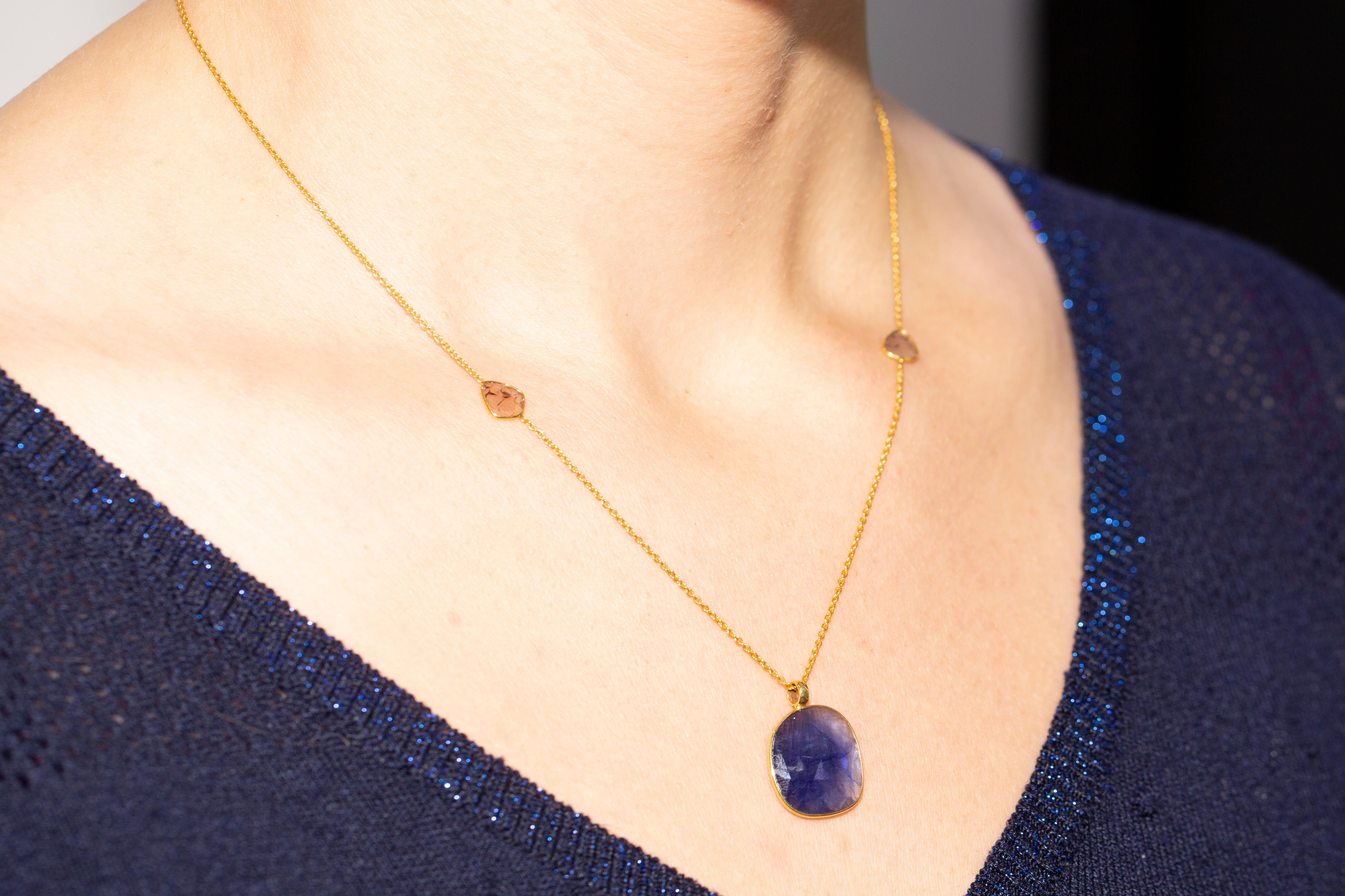 This stunning timelessly elegant rose cut 10.50 Carat Blue Sapphire from the Artisan collection is set in luxurious 18 Karat Yellow Gold chain featuring a total of 0.32 Carat Diamond slices. Each piece is hand made with a unique shaped precious