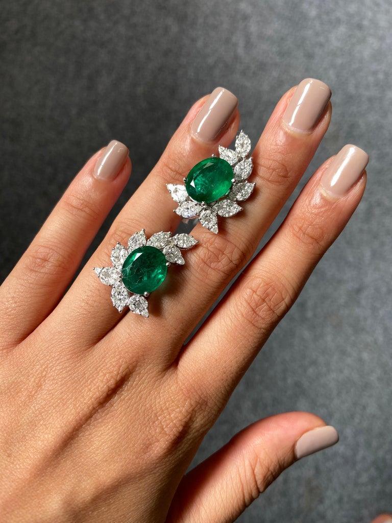 A stunning pair of natural 10.85 carat oval-shaped Zambian Emerald earrings, with 2.94 carats of VS quality colourless Diamonds (marquise and round cut) set in solid 11.44 grams of 18K White Gold. The Emeralds have great lustre, as it is completely
