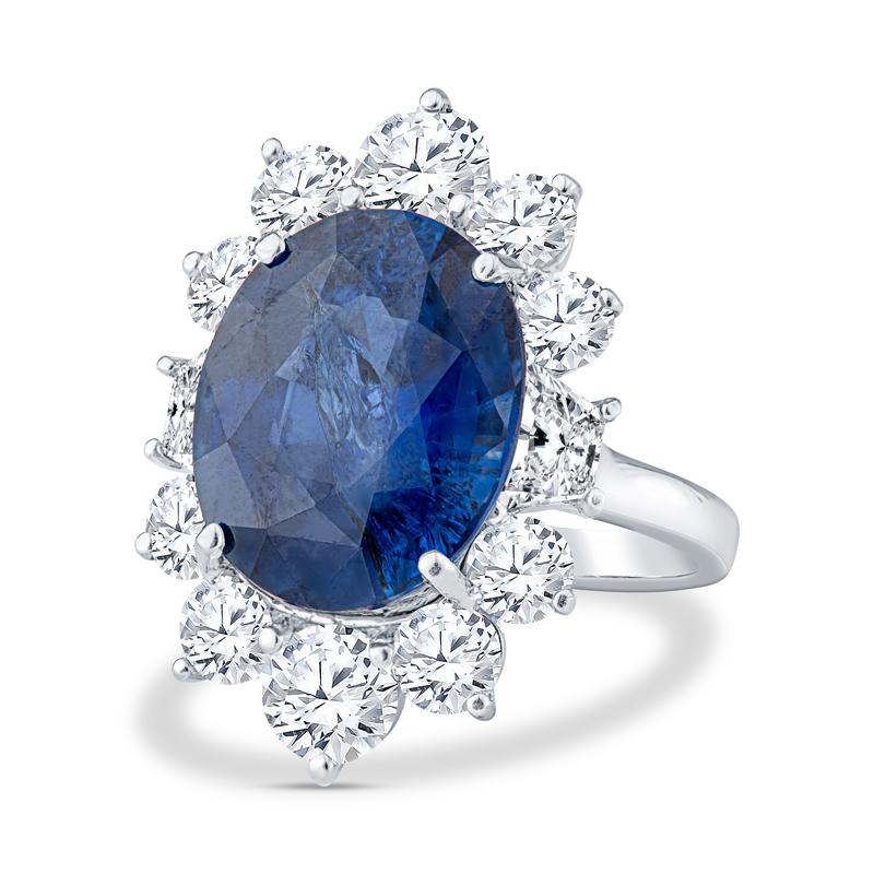 This beautiful ring is very reminiscent of Princess Diana's engagement ring. It features a jaw dropping 10.86 carat oval sapphire surrounded by 0.69 carat total weight in trapezoid diamonds and 2.80 carat total weight in round diamonds set in