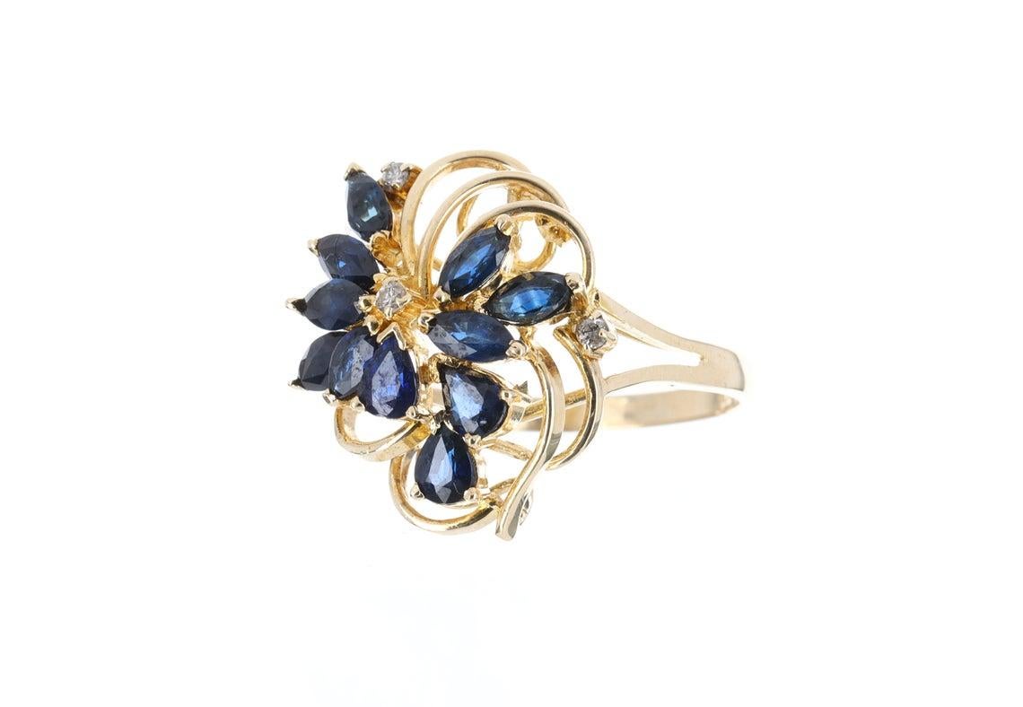 1.08tcw 14K yellow gold natural blue sapphire & diamonds cocktail ring. This piece was hand made in solid yellow gold. Numerous pear shape & marquise shaped sapphires are mixed within the setting and are 100% genuine with good qualities. Accenting