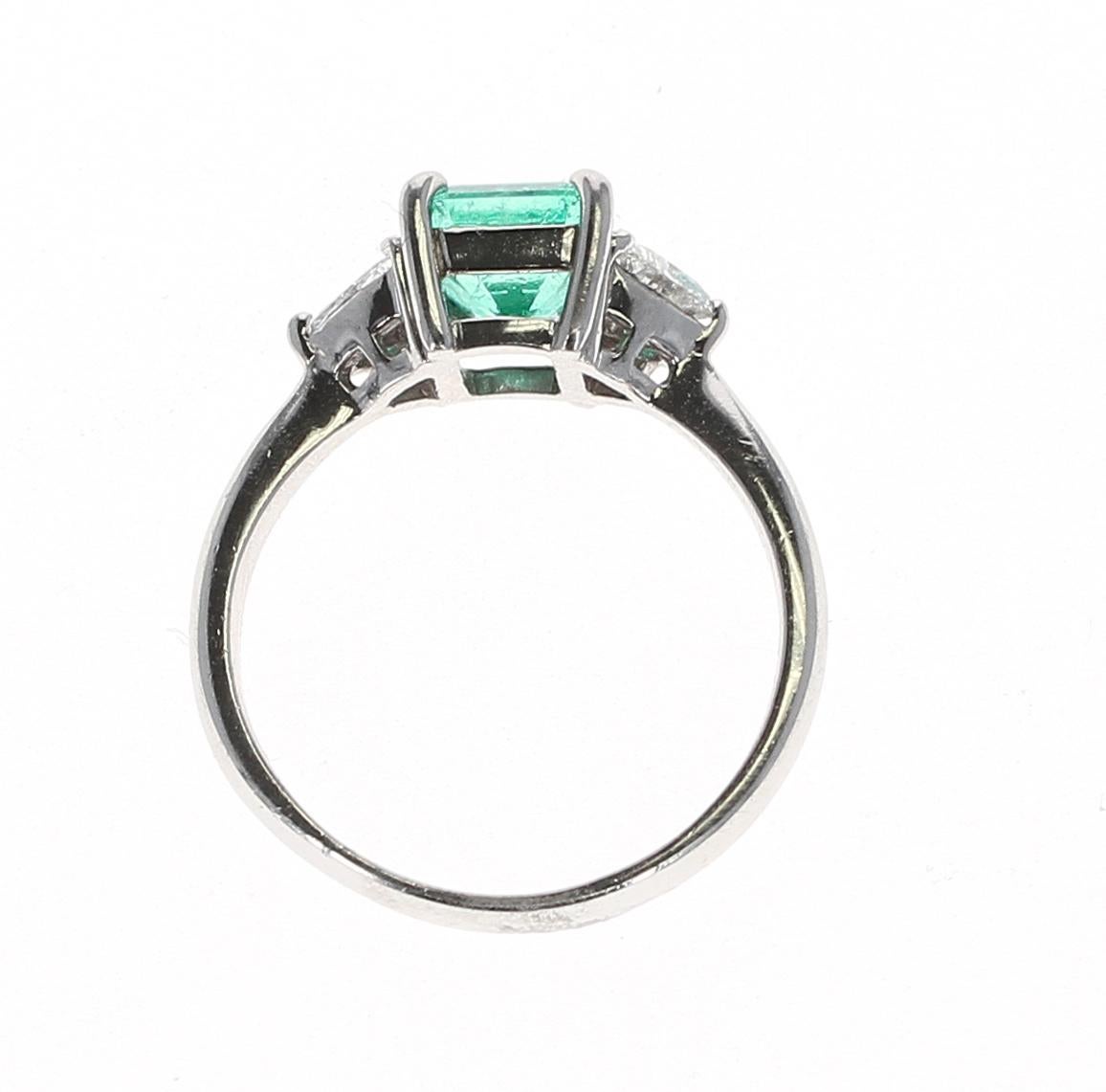Bague à trois pierres en émeraude carrée de 1,09 carat, réalisée en platine. Poids du diamant : 0,32 carats. Taille de la bague 6.25. Poids brut : 4,71 grammes. 
 