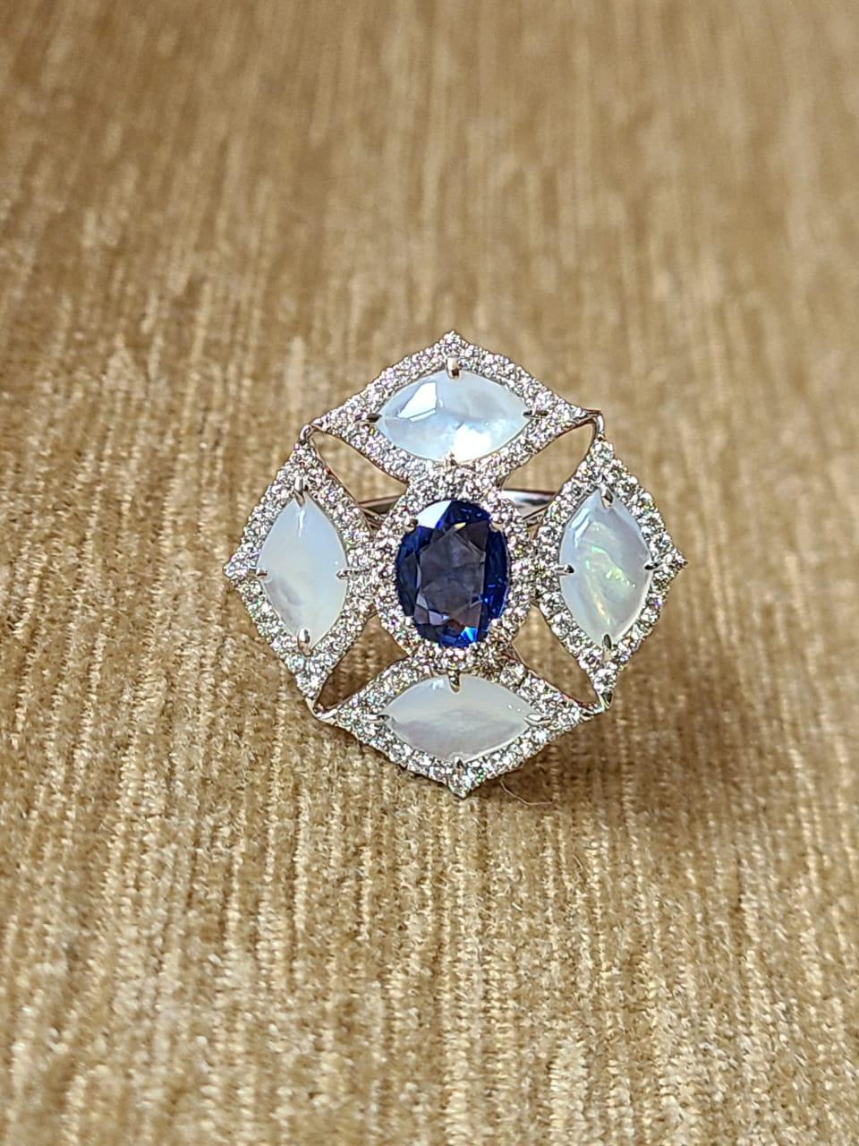 Une très belle bague cocktail en saphir bleu et nacre, sertie en or 18 carats et diamants. Le poids du saphir bleu est de 1,09 carats. Le saphir bleu est originaire de Ceylan. Le poids des 1,79 carats. Poids du diamant 0,97 carats. Le poids net de