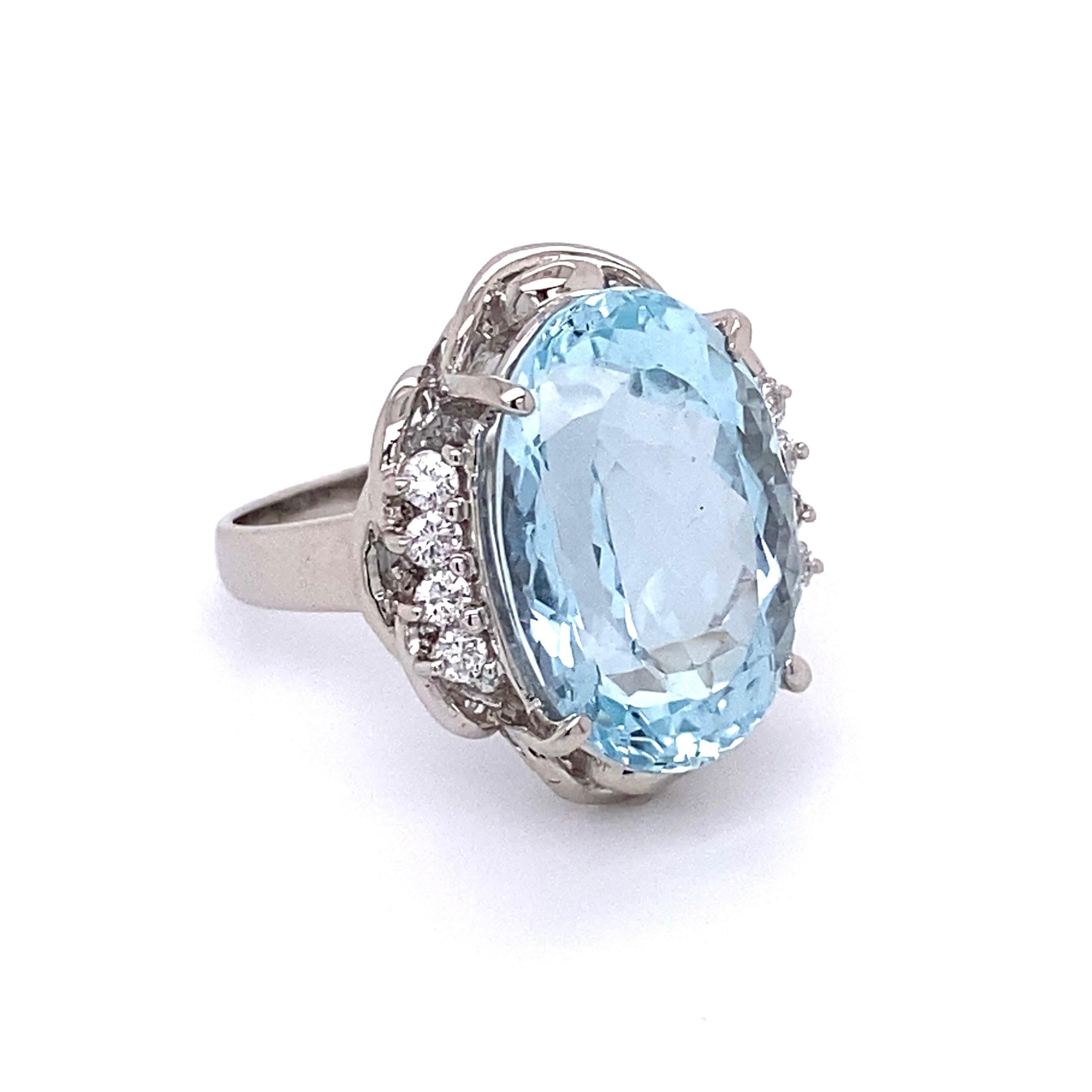 Simply Beautiful! Aquamarine and Diamond Cocktail Ring centering a securely nestled Hand set Oval Aquamarine weighing approx. 10.92 Carats, enhanced with Diamonds on either side, approx. 0.23tcw. Hand crafted Platinum mounting. Dimensions: 1.52: l x