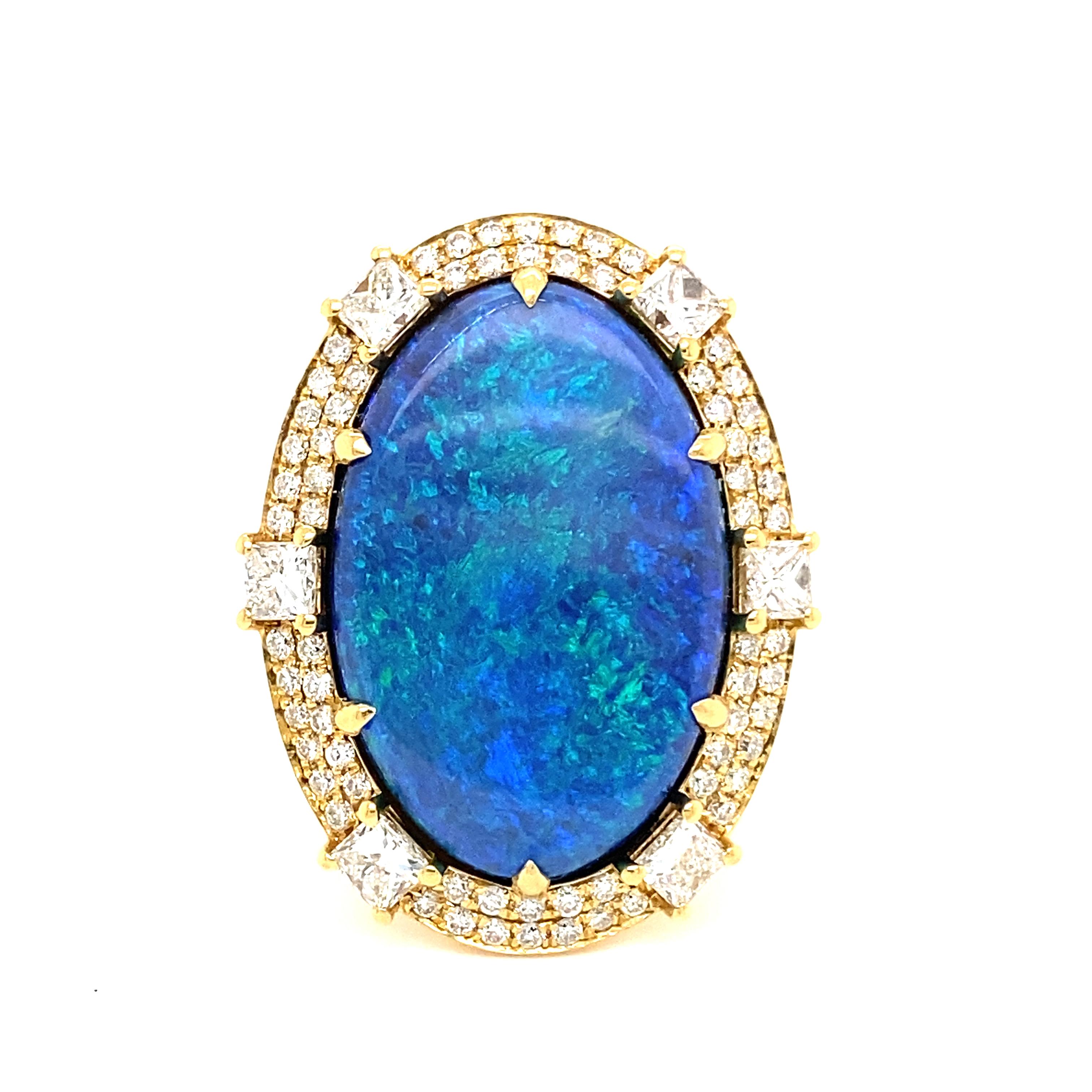 This stunning cocktail ring showcases a beautiful 10.98 Carat Oval Black Opal with a Diamond Halo on a Diamond Shank. This ring is set in 18k Yellow Gold, with 18k yellow gold prongs on the center stone.
Total Diamond Weight = 2.02 Carats. Ring Size