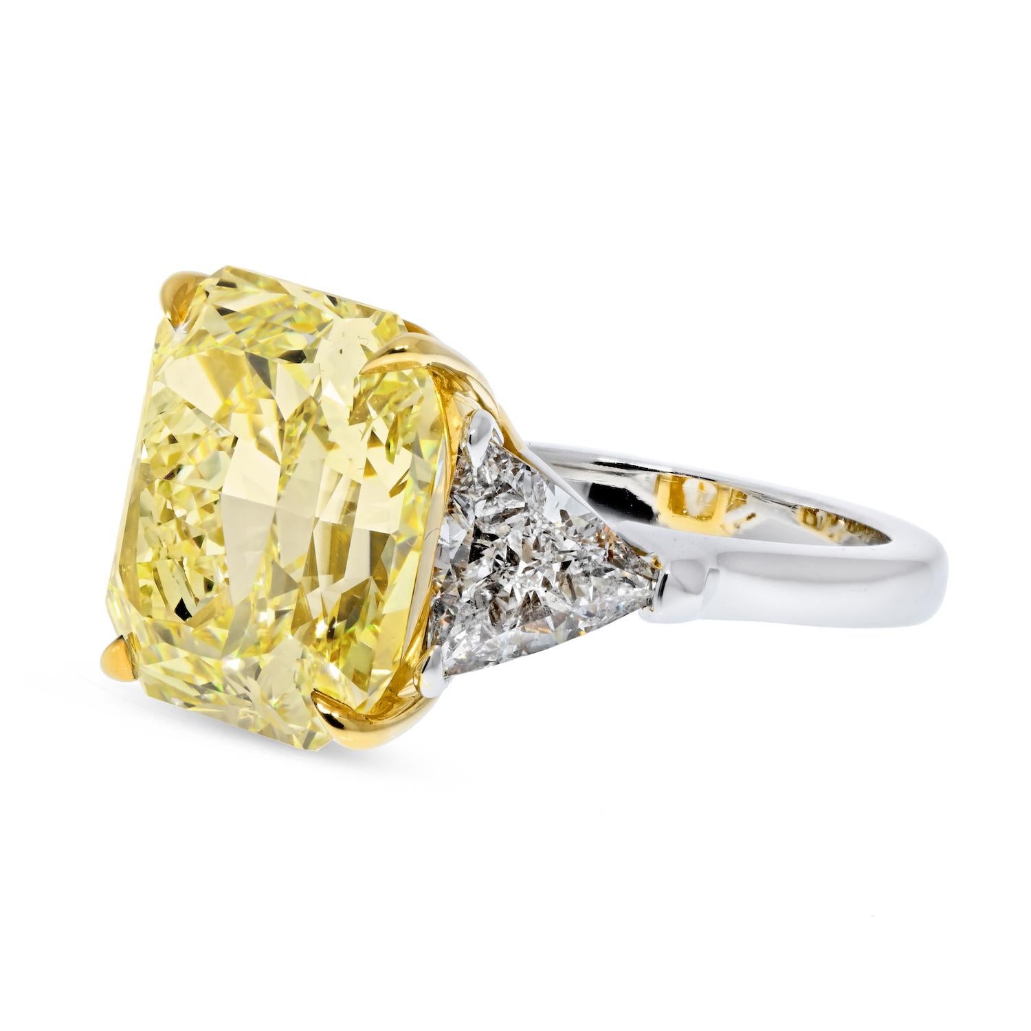 Three stone diamond engagement ring crafted in platinum and 18k yellow gold, mounted with a 10.98 carat Radiant Cut Fancy Yellow Diamond, just two points shy of a full 11 carat. It is GIA certified as Fancy Yellow color, VVS2 clarity. 

Accented
