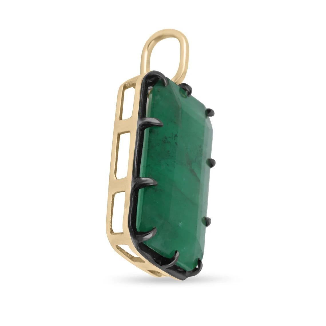Displayed is a natural emerald Georgian styled solitaire pendant in 14K yellow gold. This gorgeous solitaire pendant carries a full 10.98-carat emerald in a prong setting. Black rhodium highlights the emeralds' bezel and prongs. Fully faceted, this