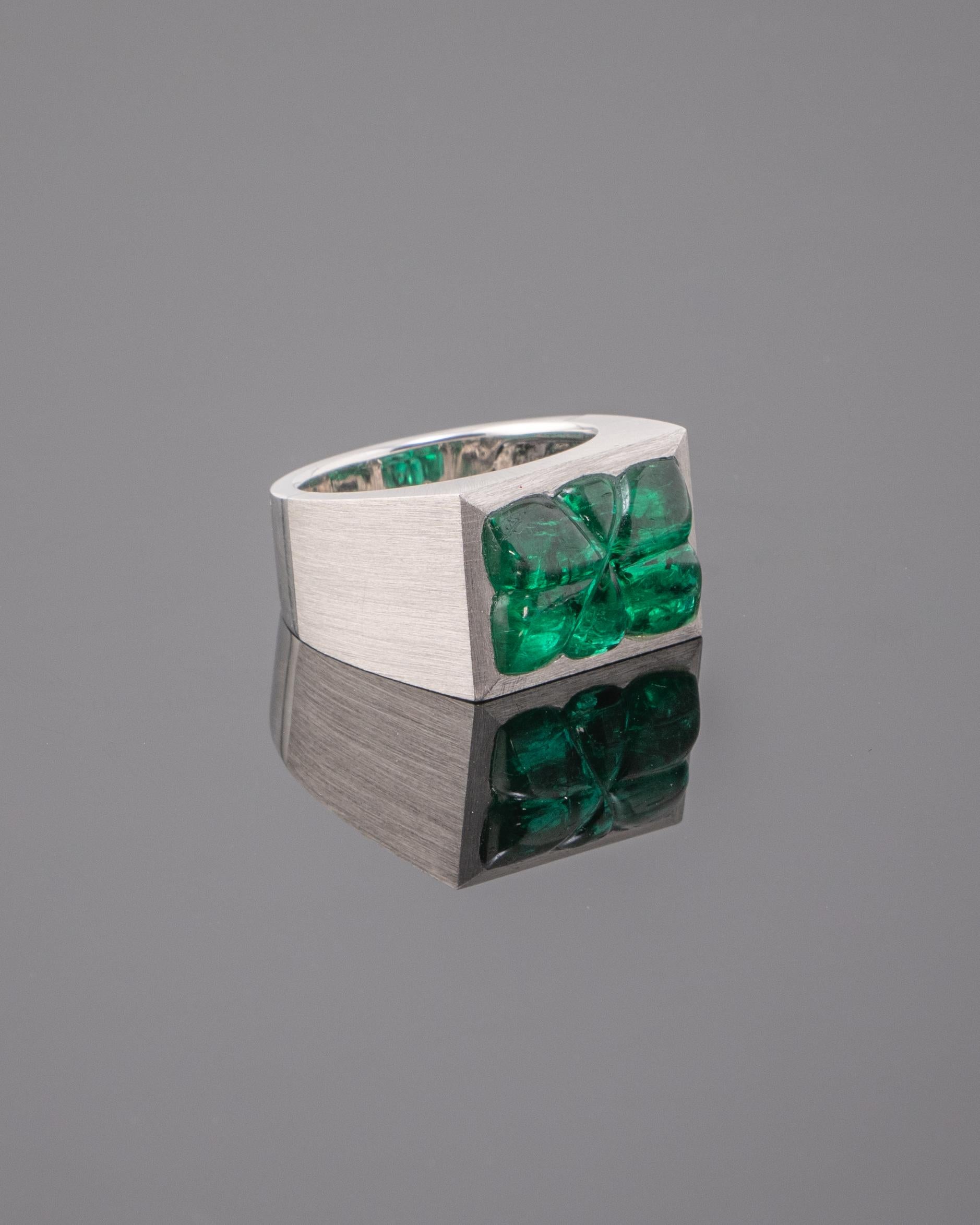 Make a statement with this stunning, unisex, 10.99 carat carved Zambian Emerald centre stone ring -  set in solid 18K white gold, with a matte finish. The carved emerald has a great lustre and is transparent, with a few natural inclusions making it