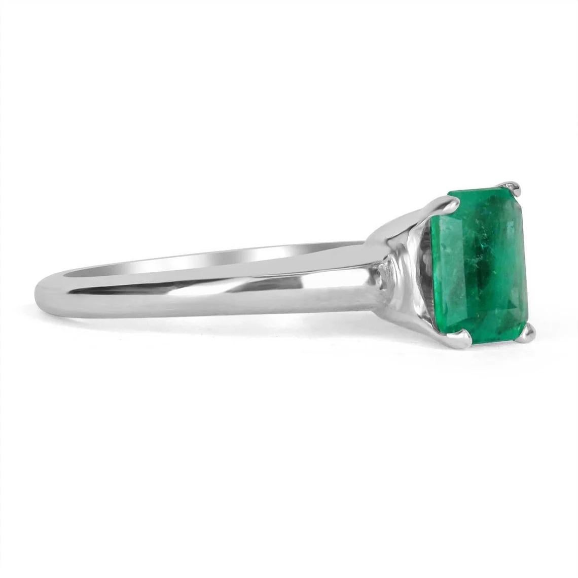 Displayed is a classic Colombian emerald solitaire, emerald-cut, engagement ring in 14K white gold. This gorgeous solitaire ring carries a full 1.09-carat emerald in a four-prong setting. Fully faceted, this gemstone showcases excellent shine. The