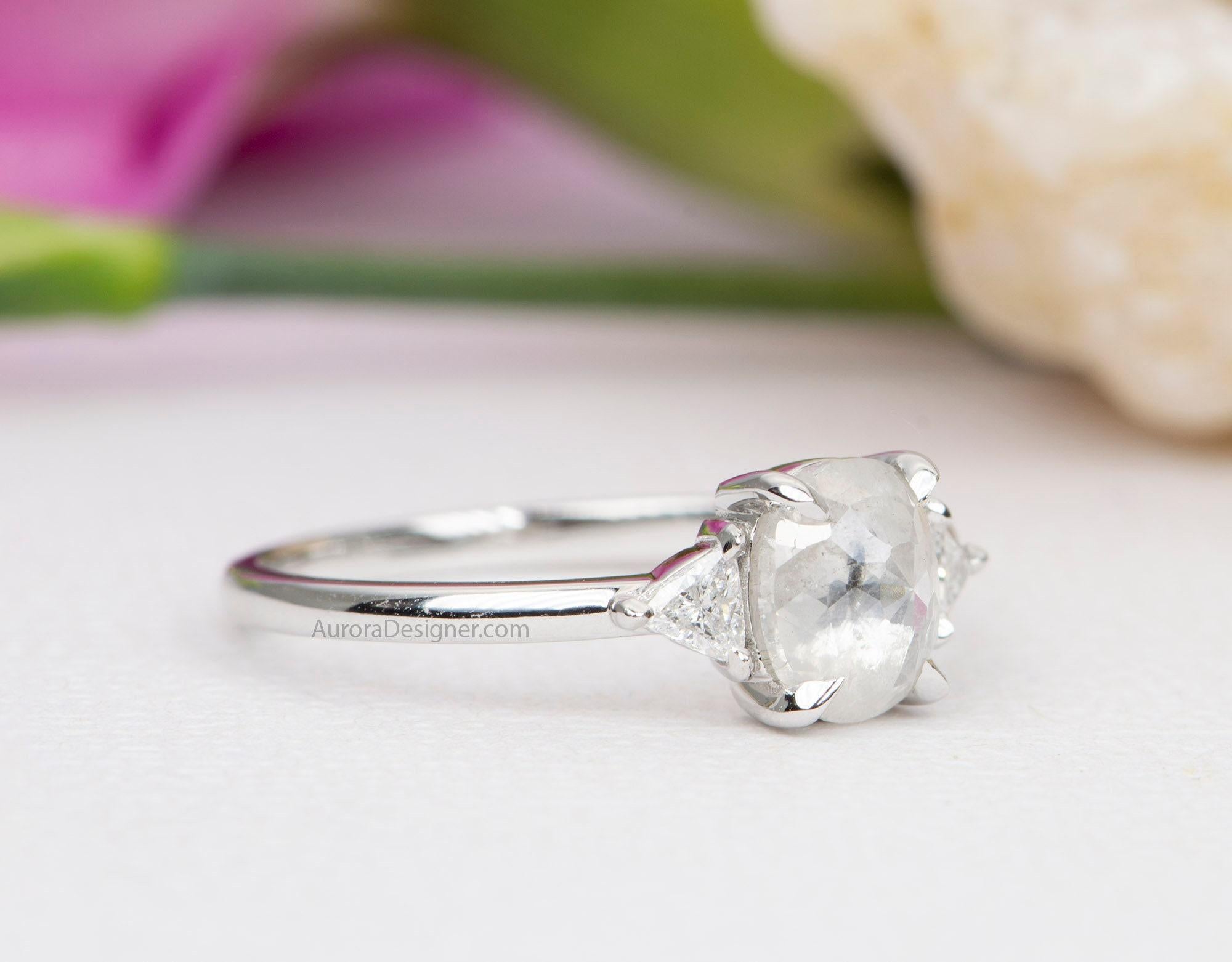 ♥  Atemberaubender Verlobungsring mit einem funkelnden milchig-weißen ovalen Diamanten, flankiert von zwei weißen Diamanten im Dreiecksschliff an der Seite
♥  Der zentrale Diamant ist meist weiß/klar mit viel Glanz. Tief im Inneren des Steins