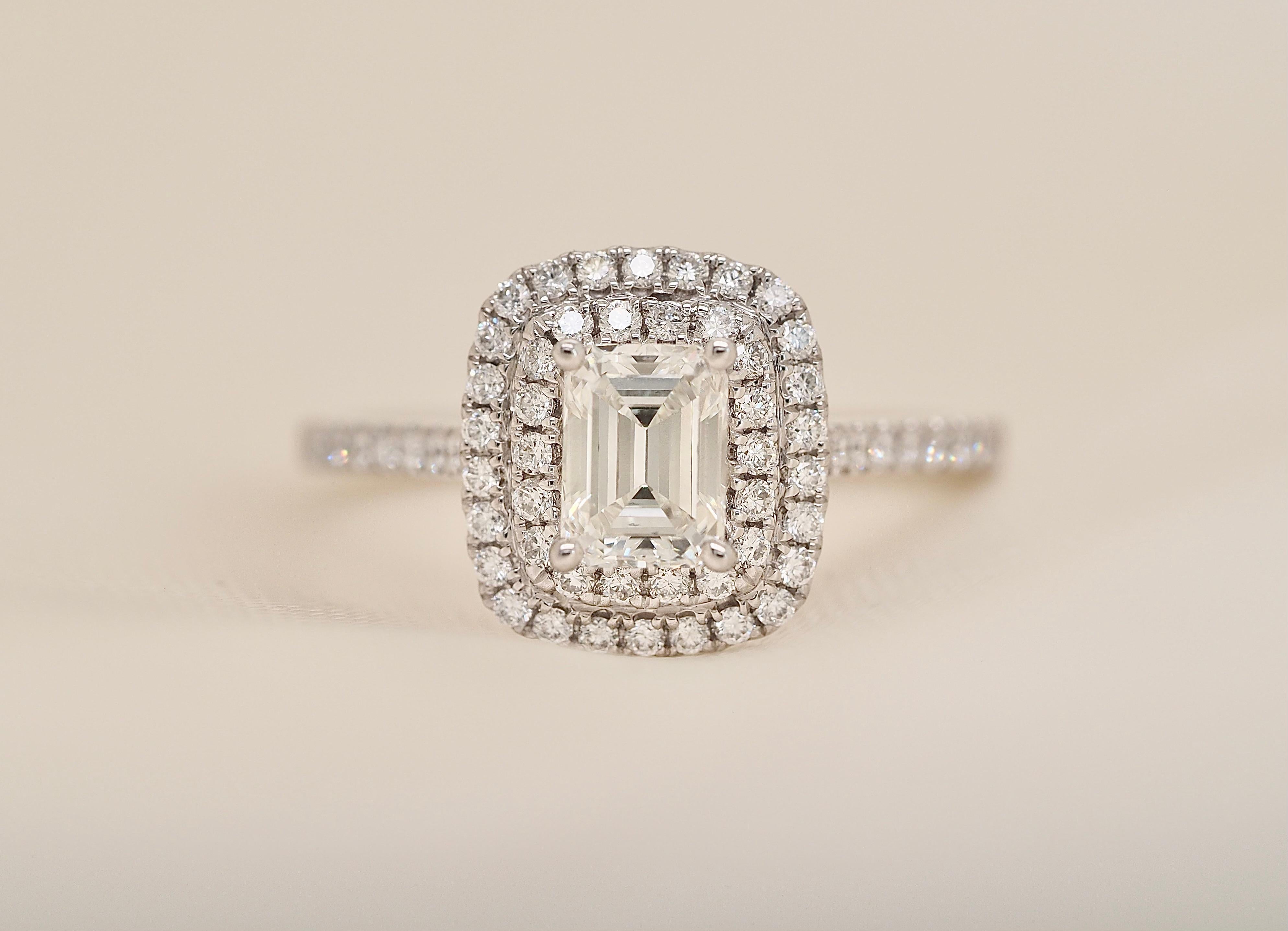 This Beautiful Brand New ring is a 1.09CTW Emerald Cut Diamond Double Halo Engagement Ring in 14k White Gold. The Center Diamond is a 0.66 carat emerald. With 0.43 Carats of round brilliant cut diamonds accenting down the side and around the