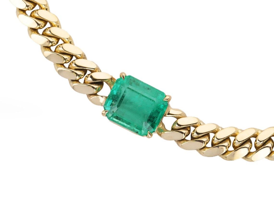 Featured here is a 10-carat stunning, East to West emerald choker necklace in 14K yellow gold. Displayed in the center is a natural emerald Colombian emerald accented by a simple prong setting, allowing for the emerald to be shown in full view. The