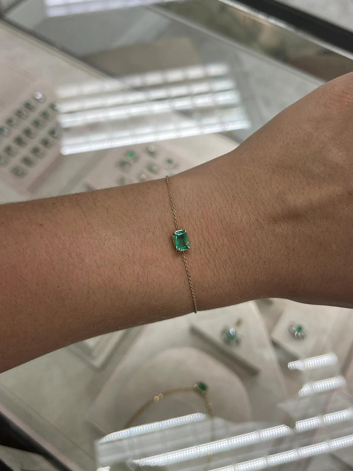 A gorgeous solitaire emerald bracelet. This piece features a remarkable emerald-cut emerald weighing a full carat of pure emerald green bliss. The gemstone showcases a ravishing medium green color with very good clarity and luster. Set in a secure