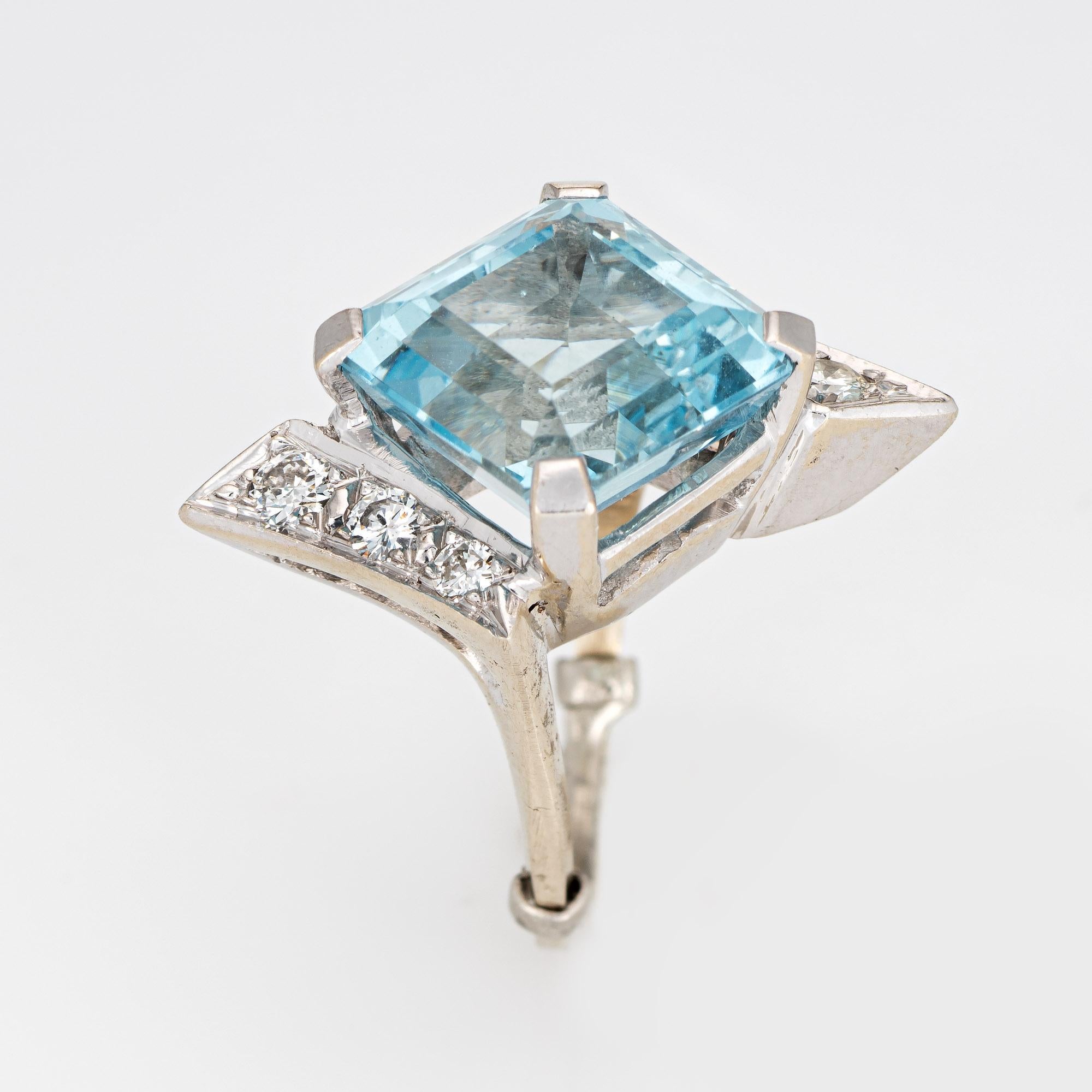 Stylish vintage aquamarine & diamond cocktail ring (circa 1960s) crafted in 14 karat white gold. 

Emerald cut aquamarine measures 12mm diameter (estimated at 10 carats), accented with an estimated 0.38 carats of diamonds (estimated at G-H color and