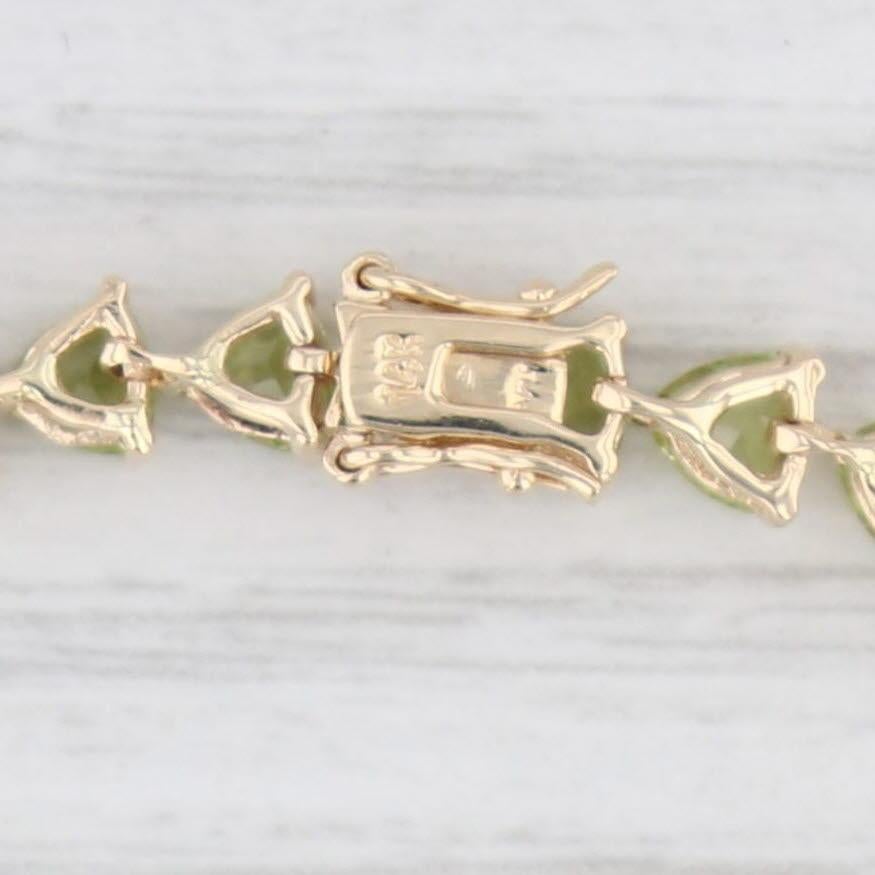 Gemstone Information:
- Natural Peridots -
Total Carats - 10ctw
Cut - Trillion
Color - Light Green 

Metal: 14k Yellow Gold
Weight: 8.5 Grams 
Stamps: 14k
Style: Tennis
Closure: Snap & Latch
Inner Circumference: 7 1/2