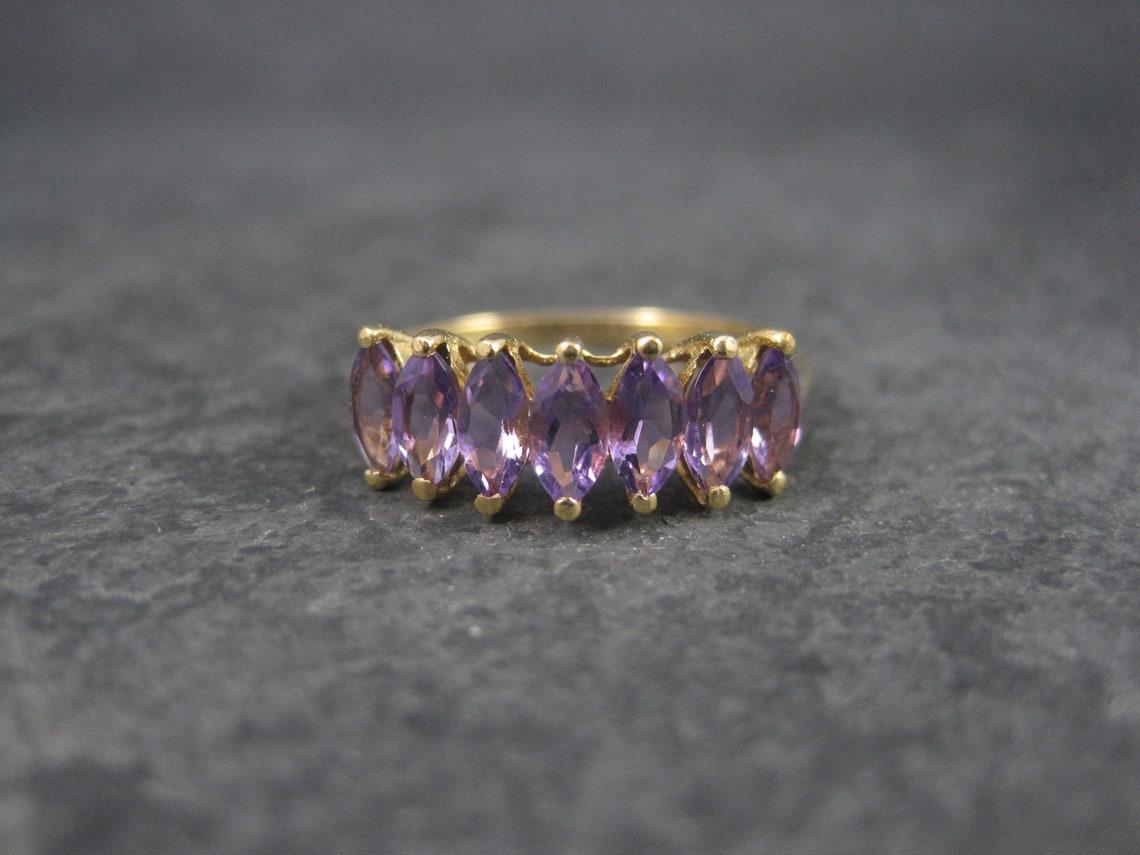 This gorgeous amethyst ring is 10k yellow gold.
It is the creation of the designer Clyde Duneier.

This ring features 1.4 total carats in marquise cut amethyst.

The face of this ring measures 1/4 of an inch north to south with a rise of 6mm off the