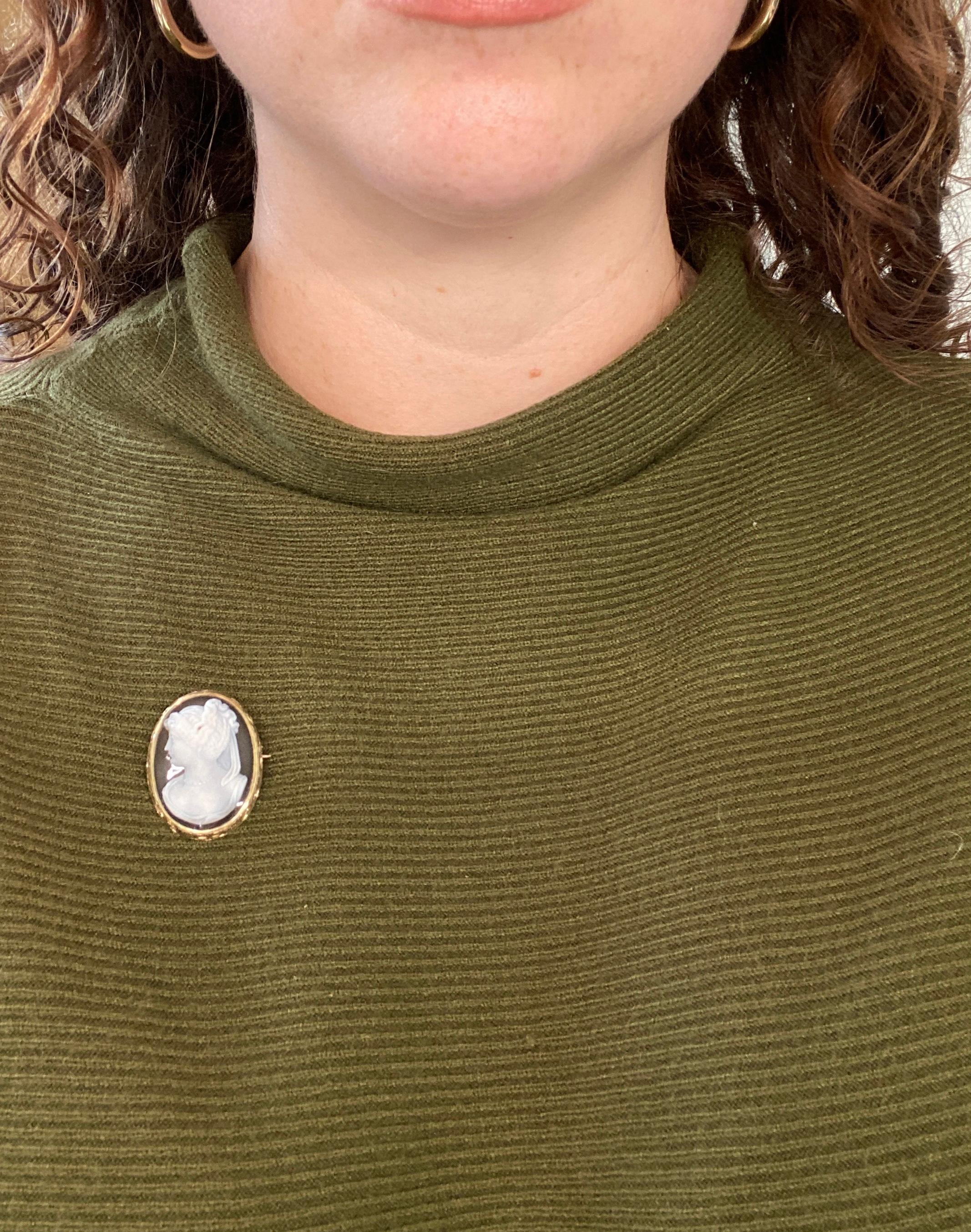 This hardstone (agate) cameo is haloed in hand-engraved 10k yellow gold. This lovely lady has beautifully coiffed hair topped with a diadem, a lovely face, and even tiny drop earrings. The attention to detail is wonderful on this antique cameo. At
