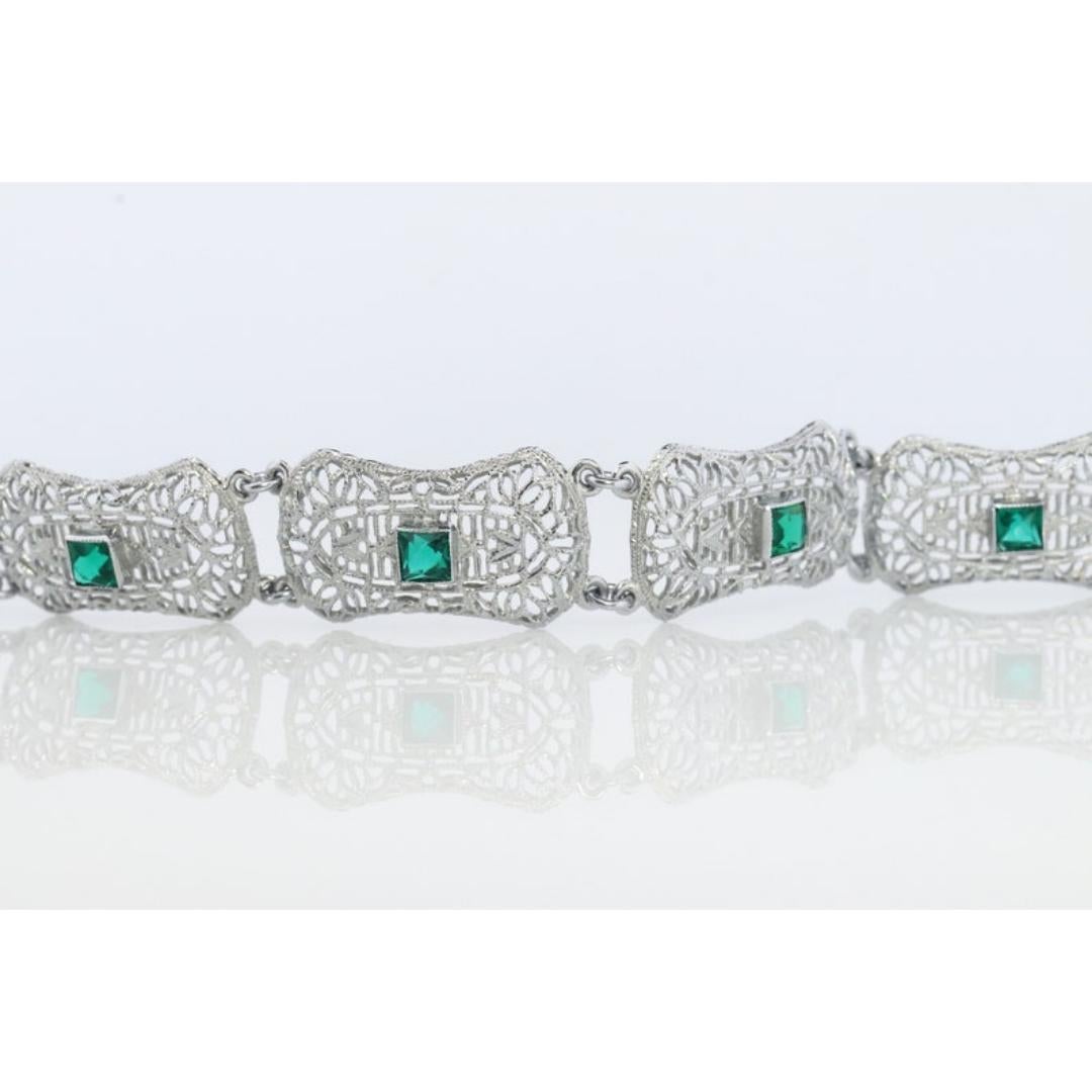 Vintage from the 1960s
Materials: Stone
Gemstone: Emerald
Chain style: Specialty chains

Closure: Slide lock

Just a beautiful delicate Bracelet.

Emeralds center set into Art Deco Bracelet.

Open Scroll Work Shield Panels.


10k White