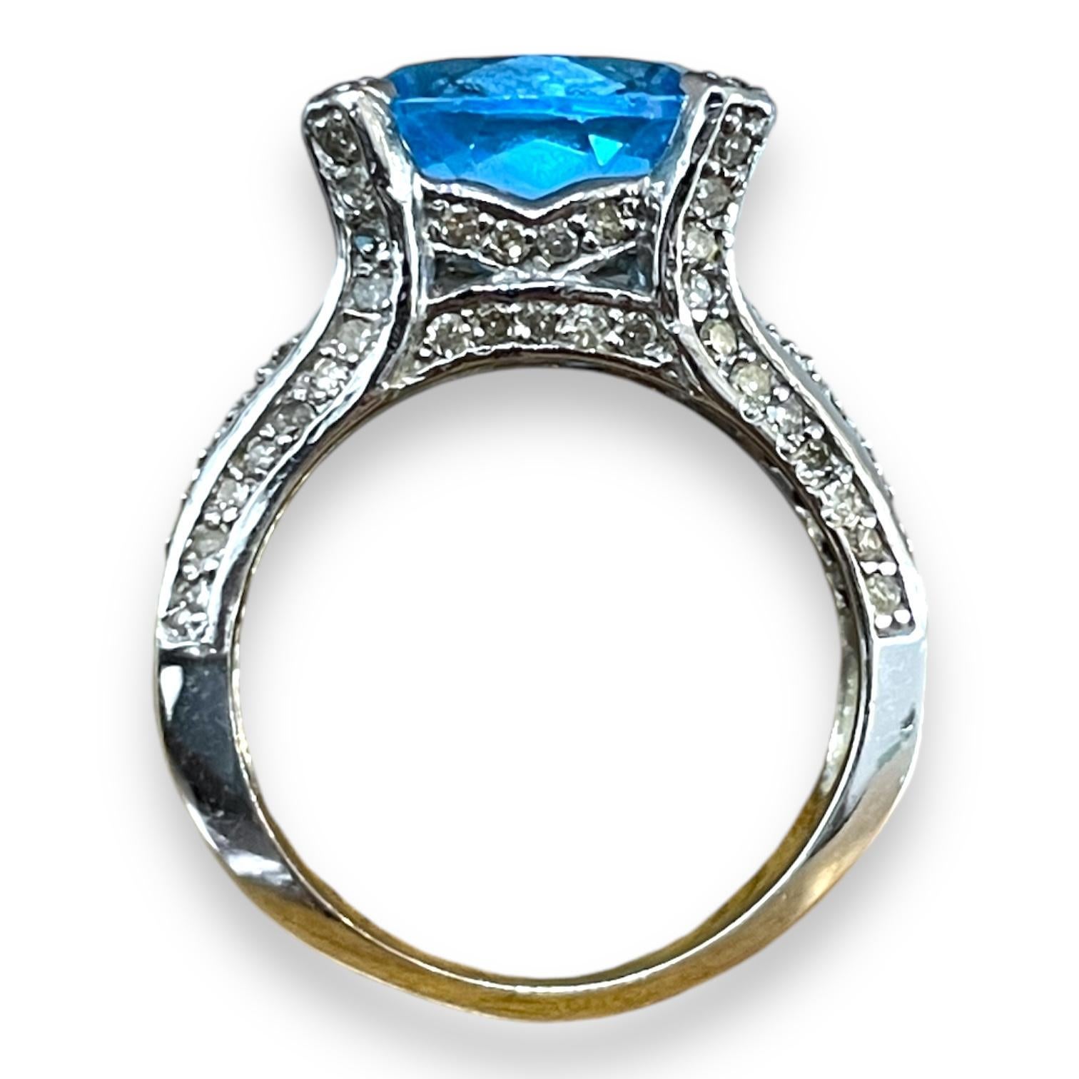 Découvrez l'attrait de cette superbe bague en or blanc, dont la pièce maîtresse est une envoûtante topaze bleue. La pierre précieuse bleu ciel est bercée par un délicat sertissage de diamants scintillants, ajoutant juste ce qu'il faut d'éclat. Le