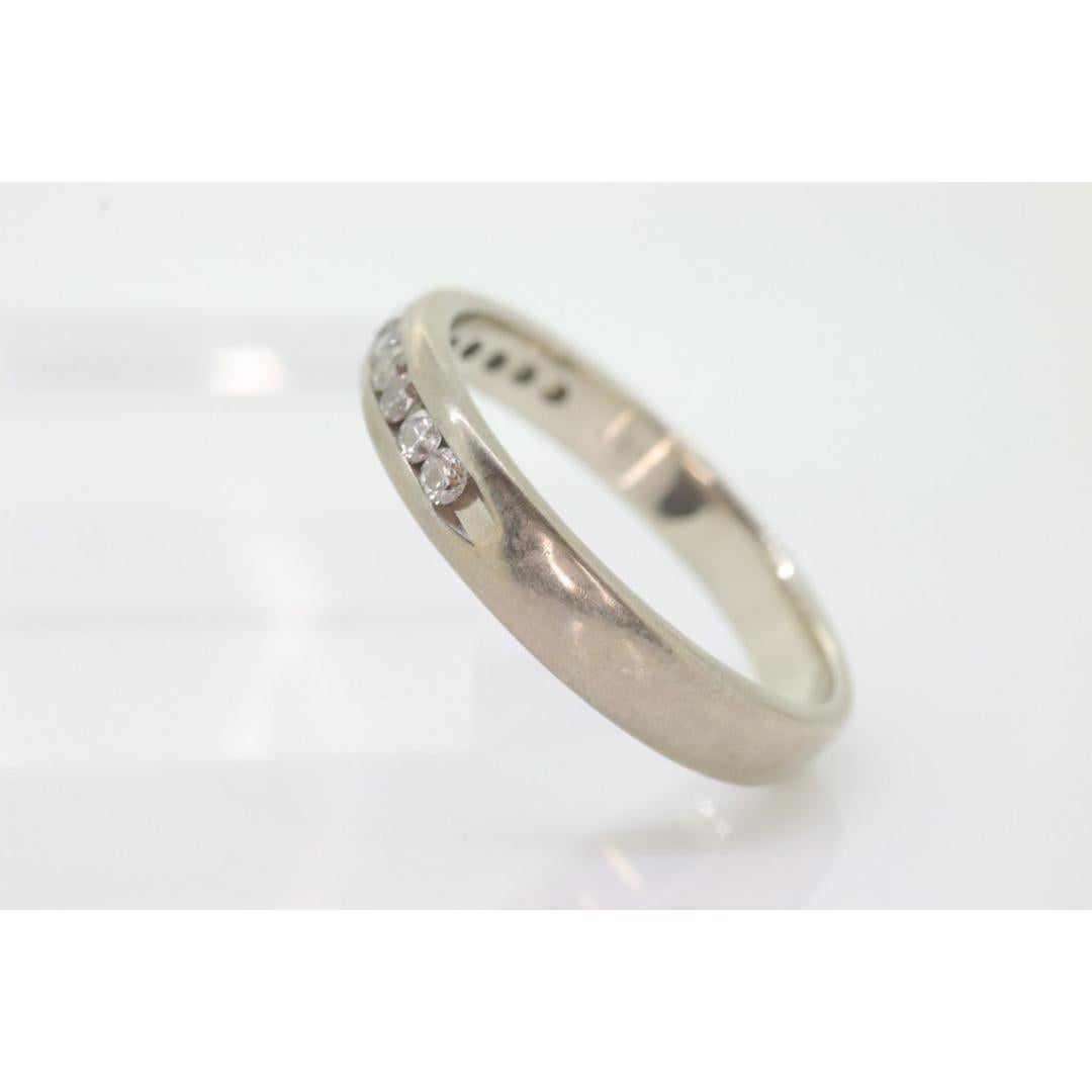 Vintage from the 1980s
Size: 12 1/4 US
Materials: Stone
Gemstone: Diamond
Gem color: Colorless
Band color: Silver

Style: Minimalist

Comfort Fit 10k Band with Channel set Diamonds.

Condition: Shows limited signs of use. Has not bee polished or