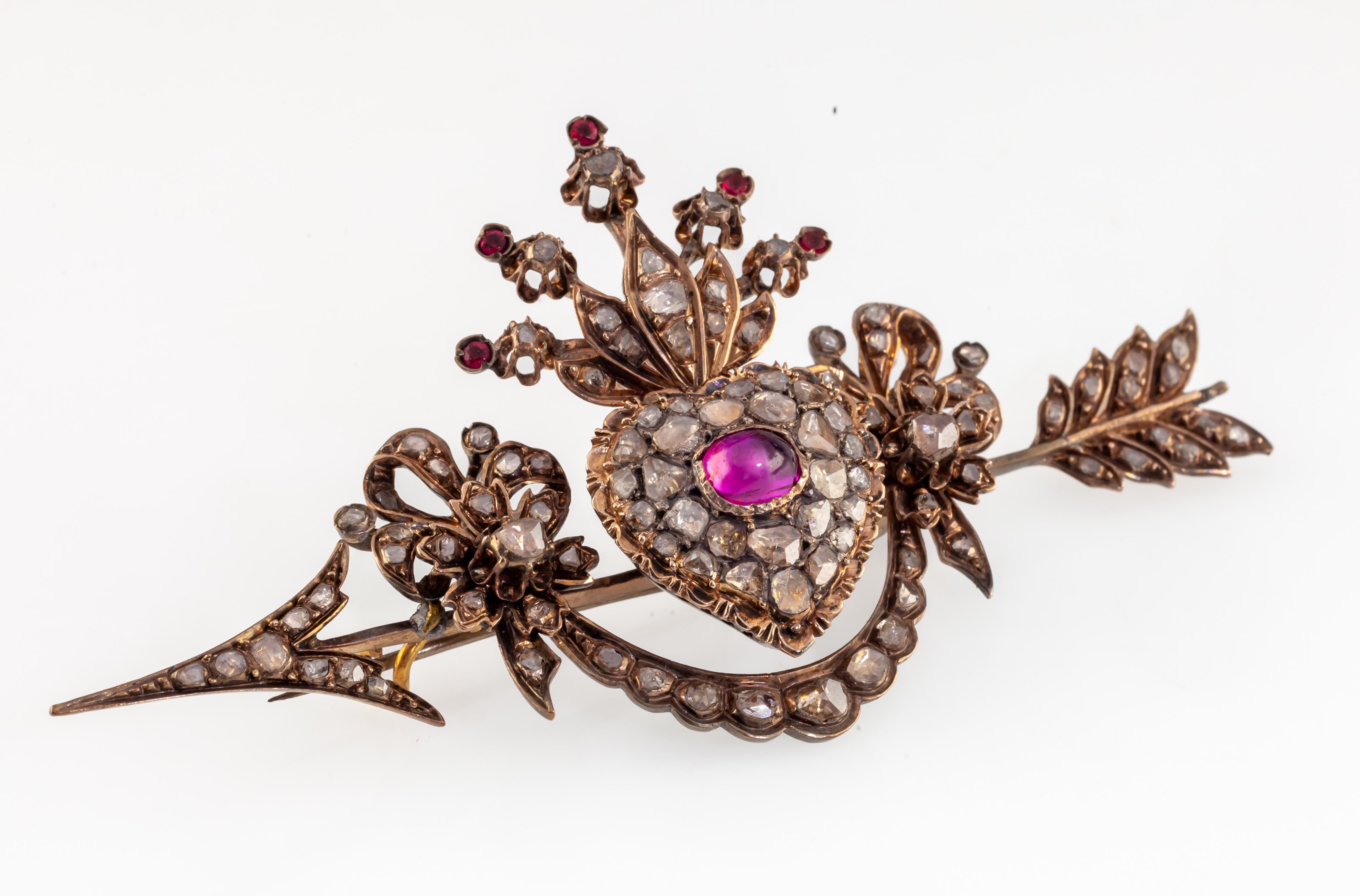 10k Gold Custom Antique Heart Arrow Brooch w/ Diamonds and Rubies
Gorgeous Antique Brooch
Features Garland with Bow Detailing on Arrow with Crowned Heart
Ruby Cabochon Centerpiece with Old Cut Diamonds
Length of Brooch = 47 mm
Width of Brooch = 90
