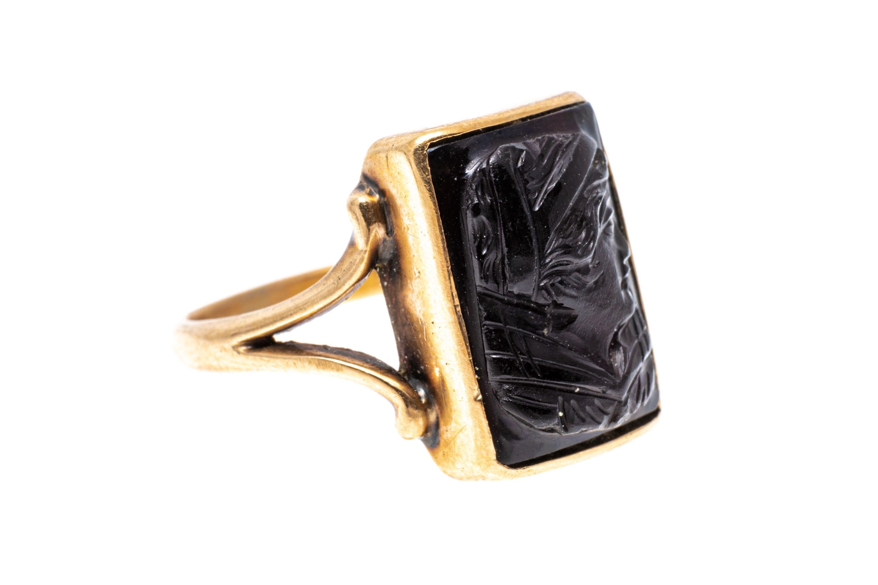 10k gold ring. This lovely vintage rectangular chalcedony cameo ring has a handsome profile bust, facing to the right, and decorated with a wide collar and banded hair. The ring is also adorned with a scrolled style split shank.
Marks: None, tests