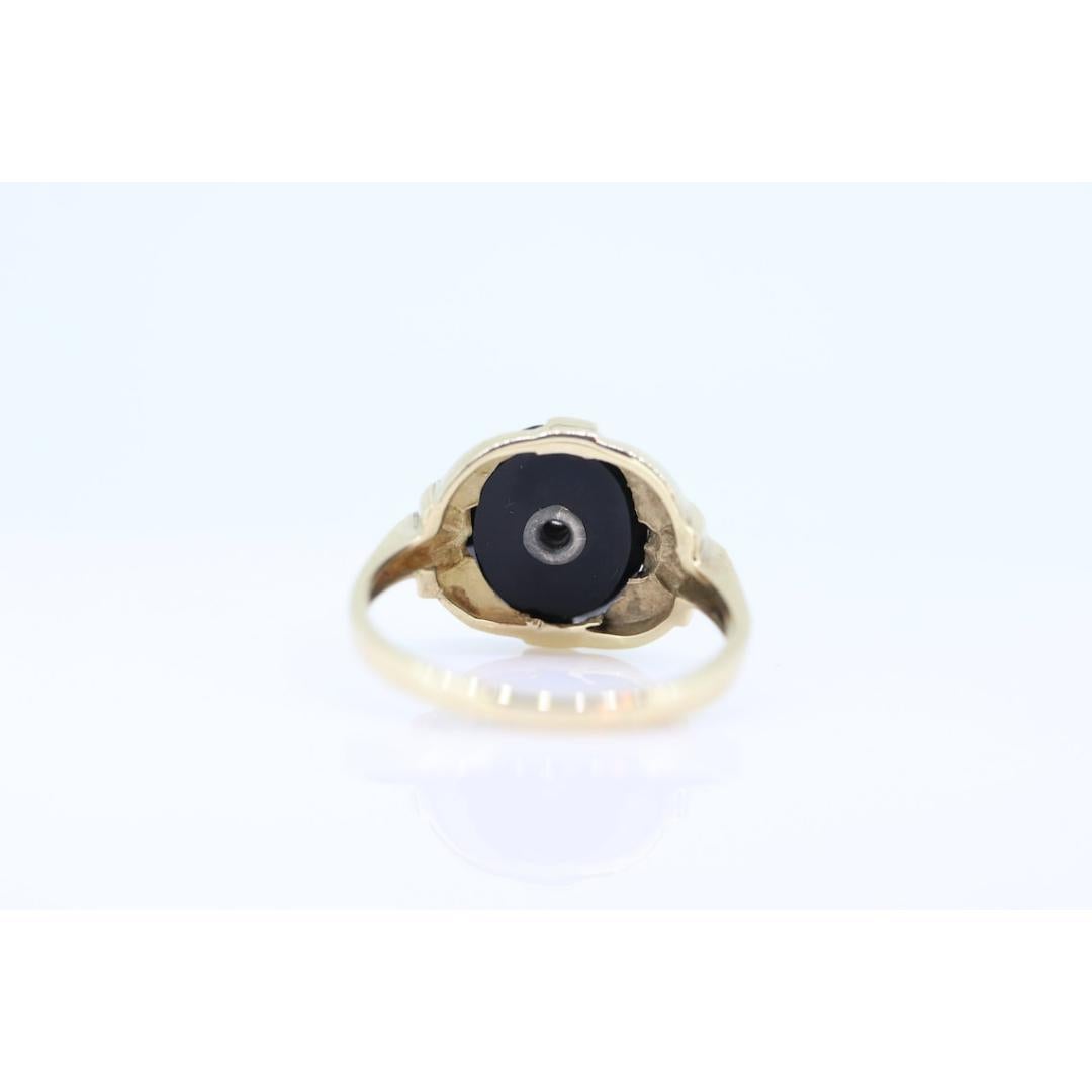 Vintage from the 1950s
Materials: Gold
Gemstone: Onyx
Gem color: Black
Band color: Rose gold

Style: Art deco

Rare Onyx and Diamond ring. 10k Gold.
2.8grams total
10mm by 12mm oval Onyx
1.5mm diamond in center
size 7.25