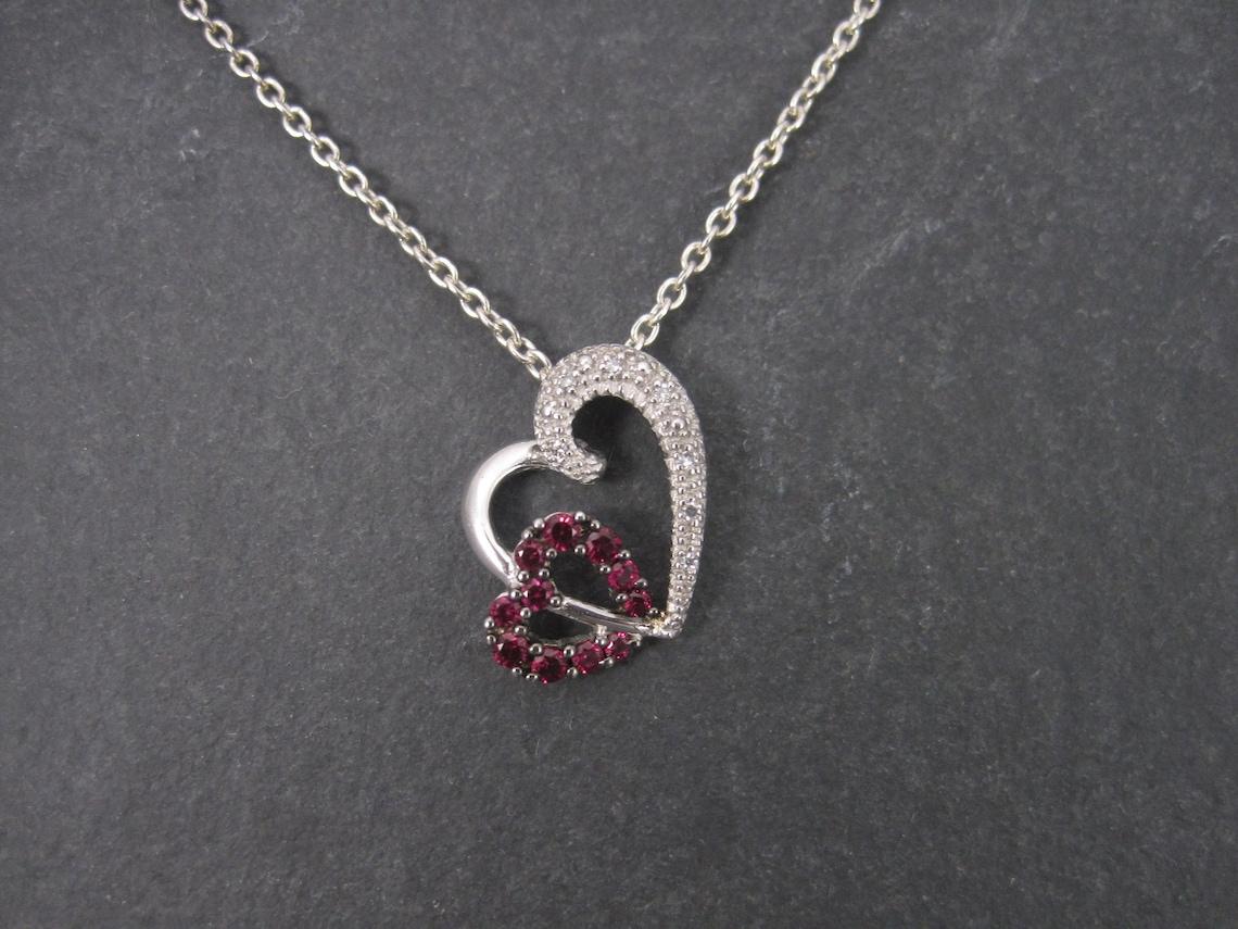 This beautiful pendant is 10k white gold.
It features .51 carats in brilliant pink sapphires and natural diamonds.

Measurements: 9/16 by 3/4 of an inch

Marks: 10K, LC, NO, 51

This pendant is the creation of L Congress Inc, a jewelry manufacturer