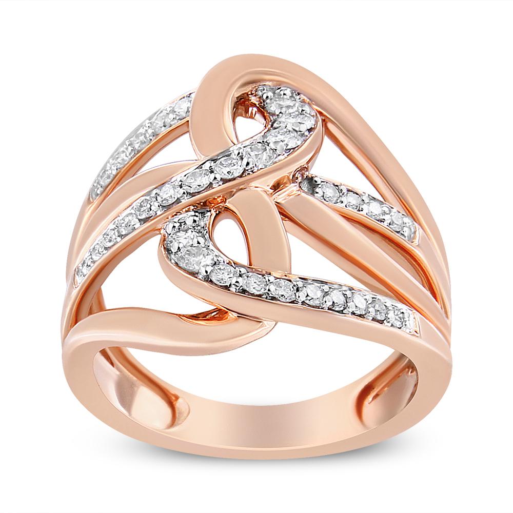 Questo anello da cocktail in oro rosa 10k è realizzato con un design unico a più anelli intrecciati. Anelli bypass in oro rosa impreziositi da diamanti naturali a taglio rotondo in una montatura a griffe. Questo anello ha un peso totale di 1/2