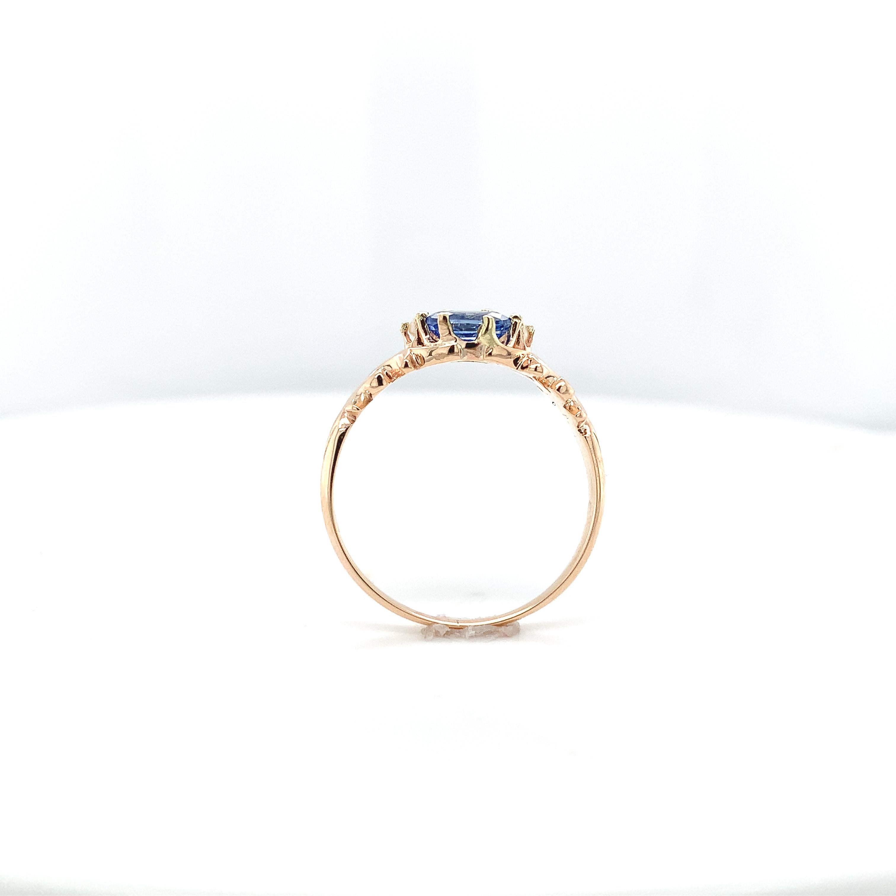 Victorian 10K rose gold ring featuring 2 oval blue sapphires.  The sapphires weigh 1.14 carats total. The sapphires are medium light lavender-blue ceylon color and measure about 6mm x 4mm. There are 2 small seed pearl accents. The ring fits a size 8