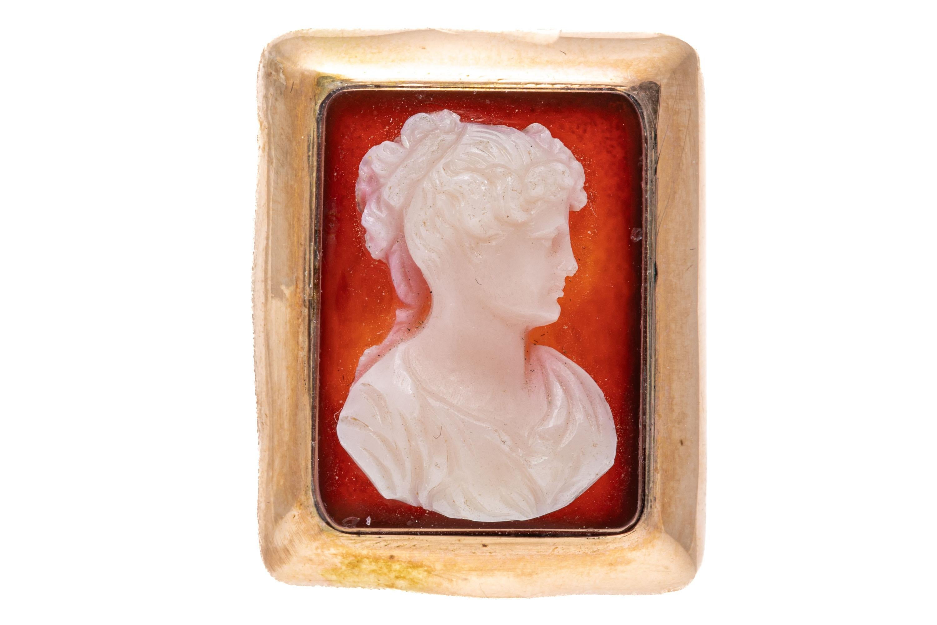 10k rose gold ring. This lovely vintage rectangular cameo ring has an orange background with a creamy white foreground of a handsome draped profile bust, facing to the right, and set off with a wide, high polished frame. The ring is also adorned