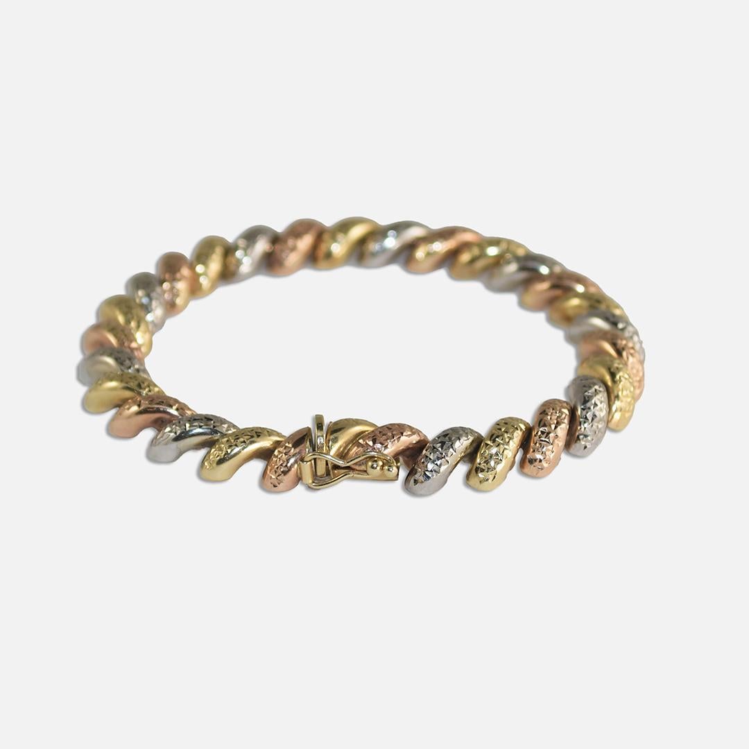 10k 3-tone San Marco bracelet with diamond cut texture surfaces.
Stamped 10k and weighs 9.8 grams. 
Rose gold, white gold, and yellow gold colors.
The bracelet measures 7 1/2 inches long and 8mm wide.
Excellent condition. 