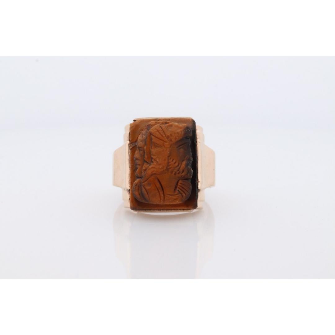 Vintage from the 1930s
Size: 8 1/4 US
Materials: Stone
Gemstone: Tiger's eye
Gem color: Champagne
Band Color: Bronze

Style: Art deco

Amazing Heavy Carved ring. Very unique translucent Tiger's Eye stone. I have not seen one like it. Triple head
