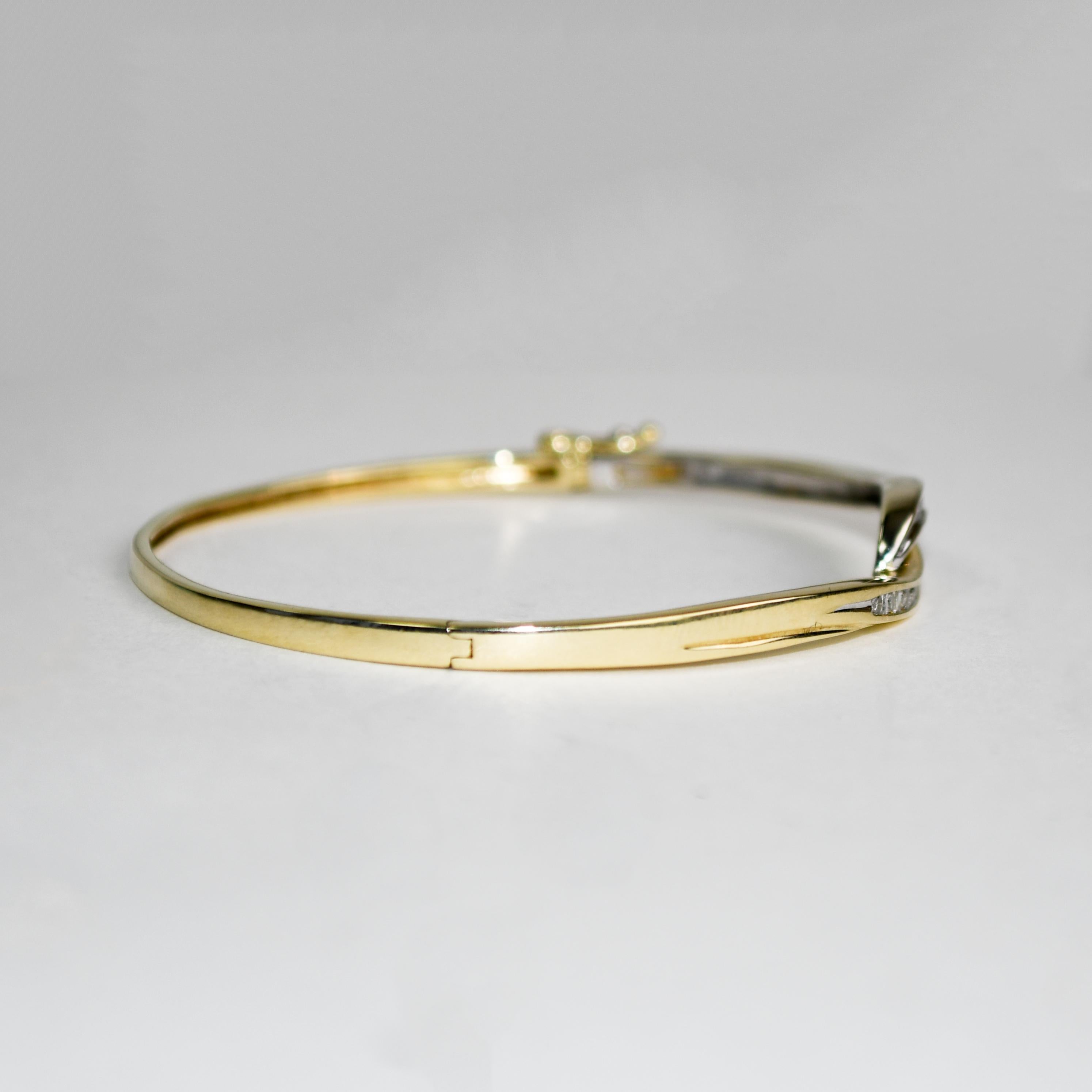 Bracelet bangle en or jaune et blanc 10k et diamants.
Estampillé 10k, 1/4 TW et pèse 9,1 grammes.
La partie supérieure du bracelet est en or blanc d'un côté et en or jaune de l'autre.
Il y a des diamants ronds de taille brillant et des diamants de