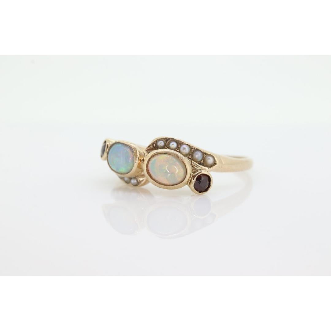 Vintage from the 1900s
Materials: Stone
Gemstone: Opal
Gem color: White
Band color: Gold

Style: Victorian

10k gold unmarked but tests appropriately
4mm by 5mm twin opals.
2mm pearl seeds
2.5mm garnets
2.5grams total weight
7.5mm wide top

Stunning