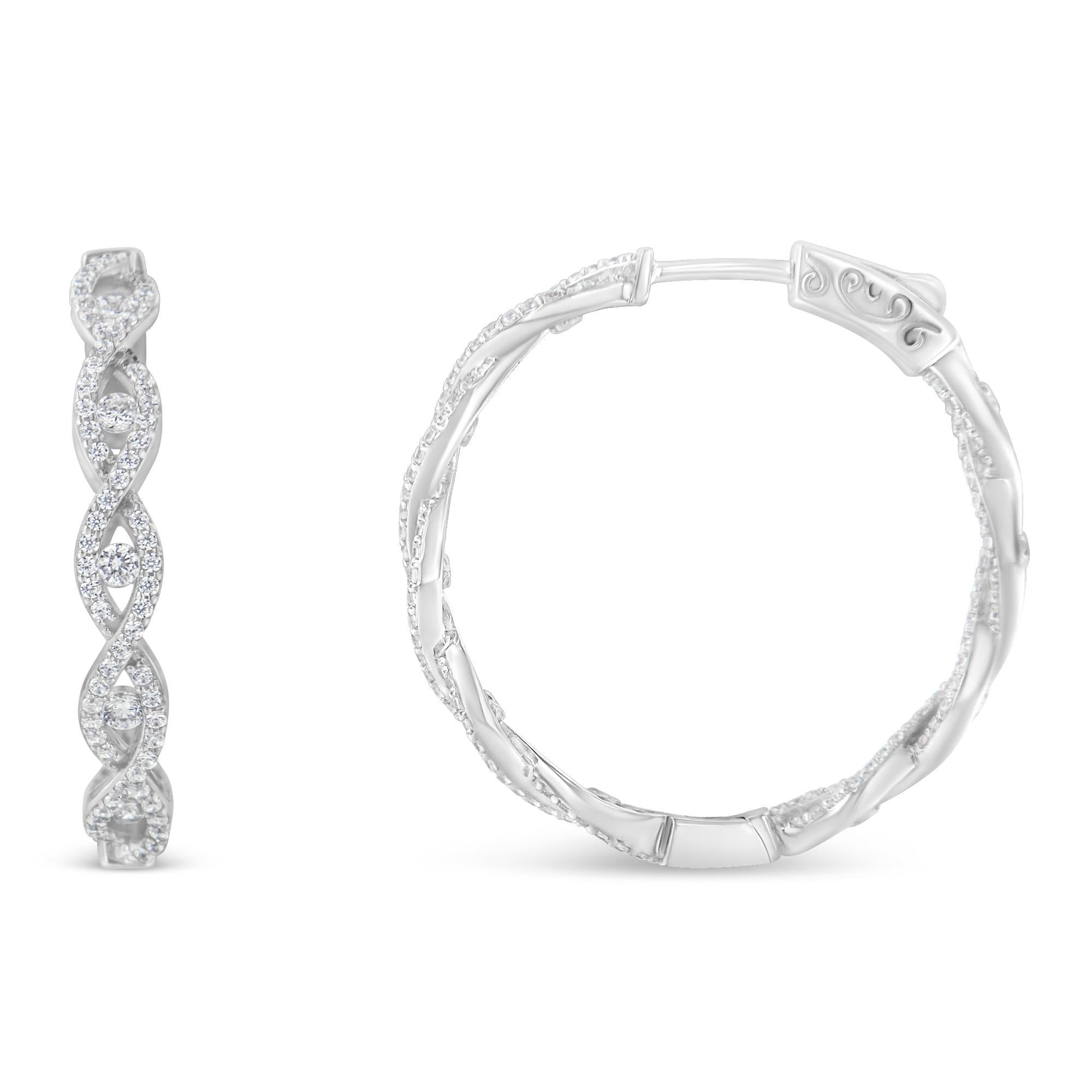 A pair of elegant diamond drop earrings features an elongated infinity design set with diamonds. Each infinity shape has a central round diamond for extra sparkle. Crafted in 10 karat white gold, they have a total diamond weight of 1 1/2 carats.