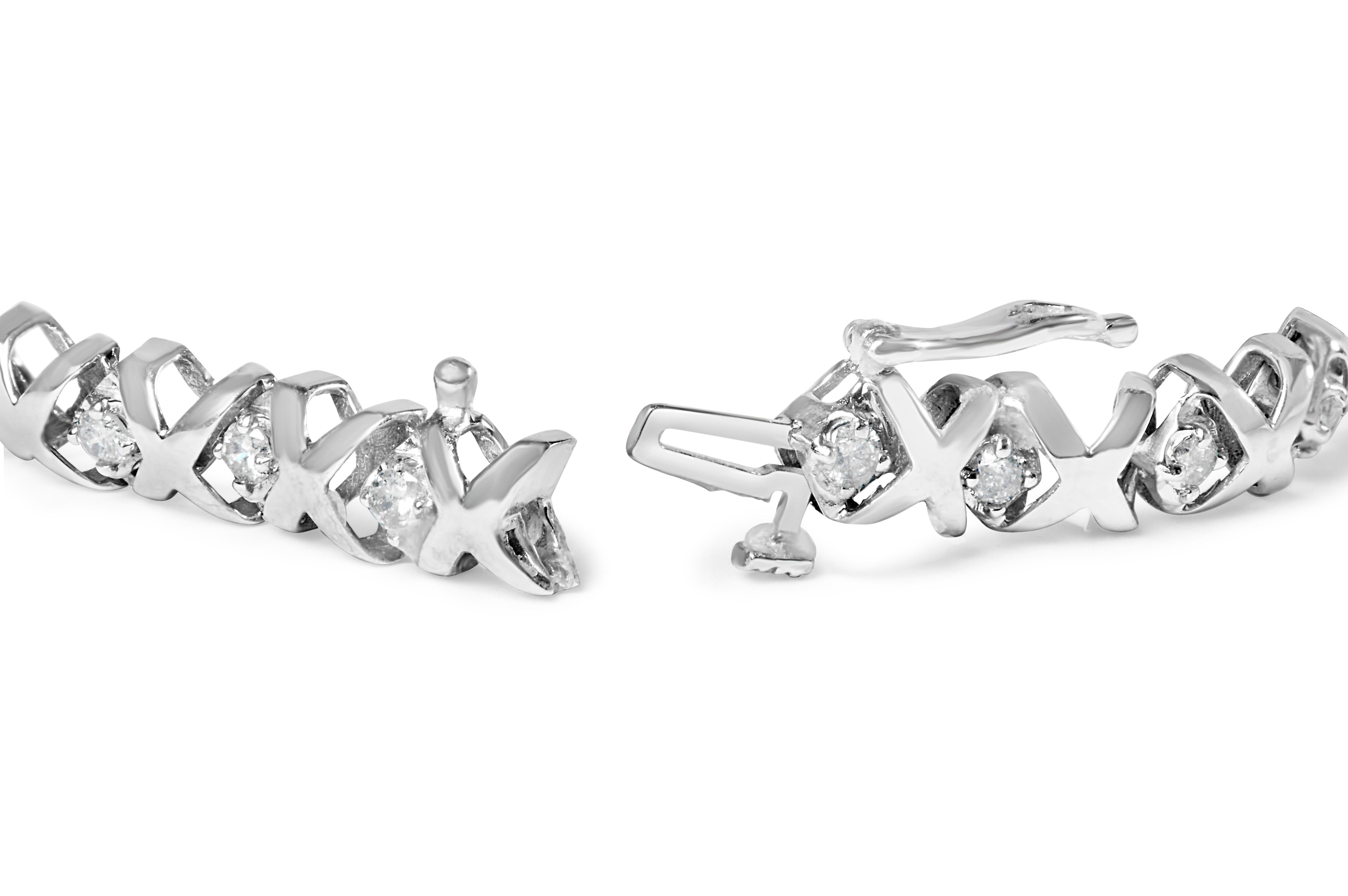 Deléitate con el máximo lujo con esta impresionante Pulsera de Tenis X-Link de Diamantes en Oro Blanco de 10 quilates. Con 56 diamantes redondos naturales que suman 1,5 quilates, esta pulsera es un auténtico espectáculo. La alternancia de diamantes