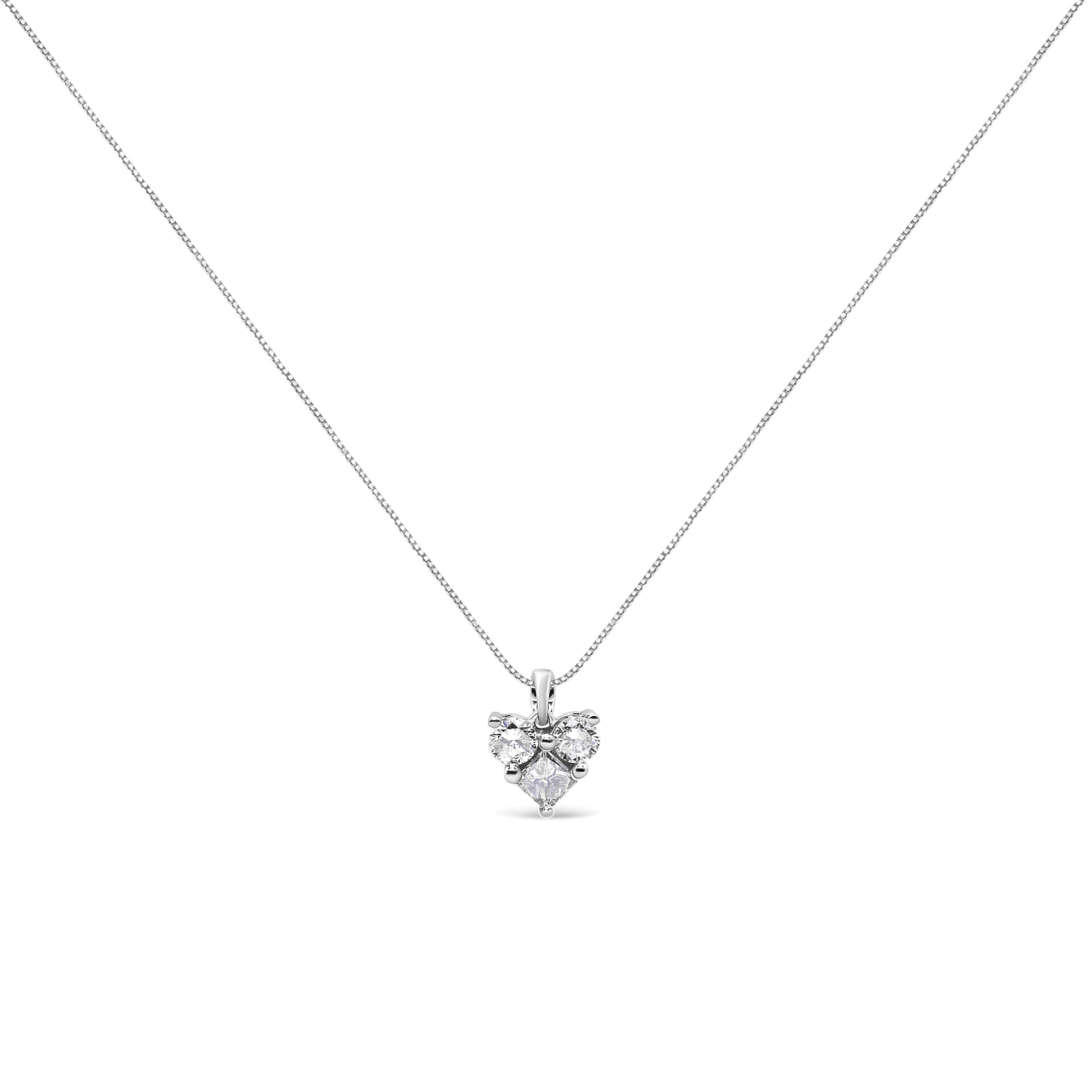 A meaningful symbol of love, this diamond heart pendant brings extraordinary sparkle with three sensational diamonds. One princess cut diamond and two round shaped diamonds come together to create the illusion of a heart shape in a prong setting to