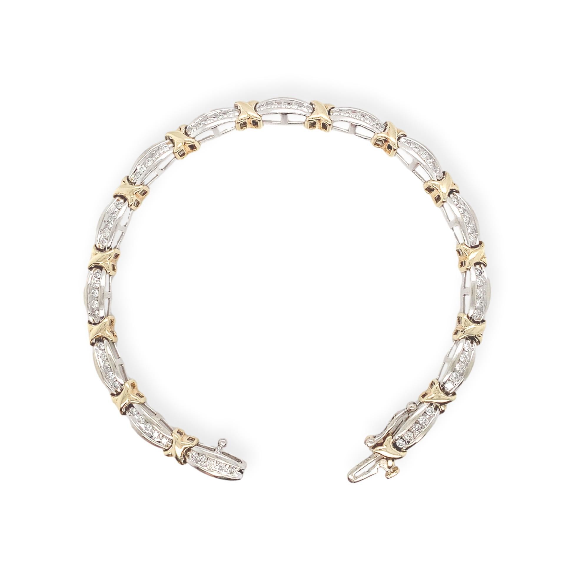 10K White gold diamond tennis bracelet with yellow gold x shaped accent links. There are 14 white gold links each with 5 channel set round brilliant cut diamonds. There are a total of 70 diamonds weighing about 1.40 carats total. The bracelet