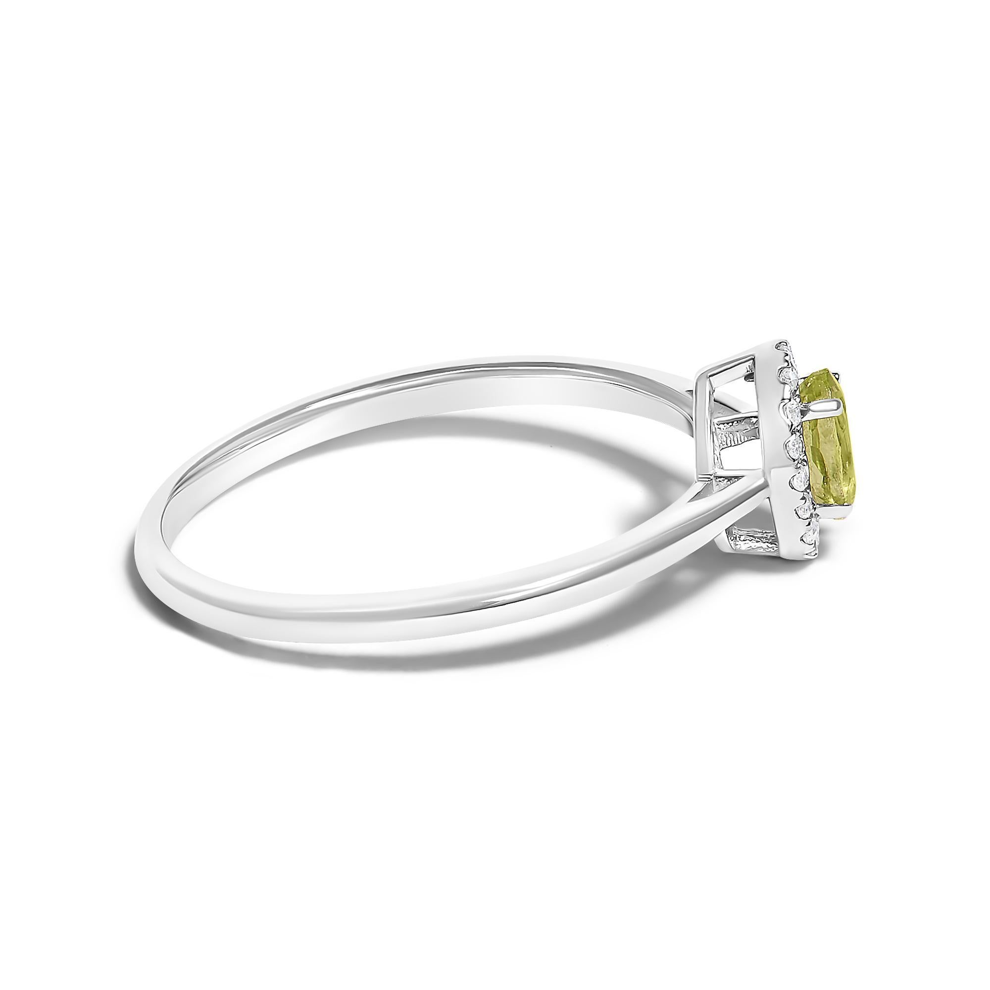 Elegant and radiant, this exquisite ring is a symphony of color and light, masterfully crafted from rhodium-plated 10K white gold to ensure an enduring gleam. At its heart lies a mesmerizing 5x3mm oval green peridot, its vibrant, untreated hues