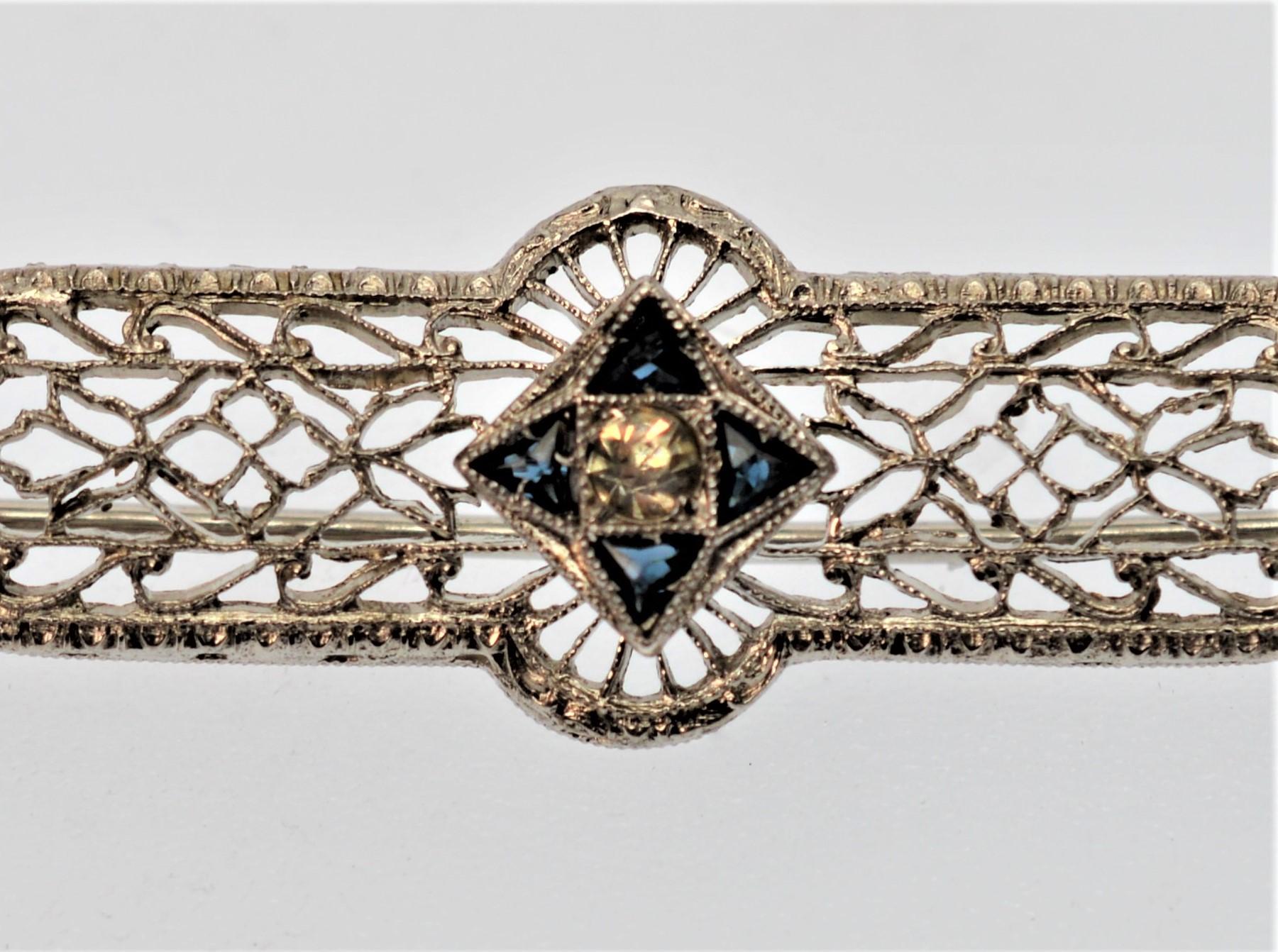 Pretty heirloom piece. Measuring 2-3/4 inches in length and 1/2 inch wide, this Antique Filigree Bar Pin is crafted of 2.5 pennyweight of 10K White Gold and adorned with a feature center-star of Blue and White Rose Cut Sapphires. Total weight 2.5