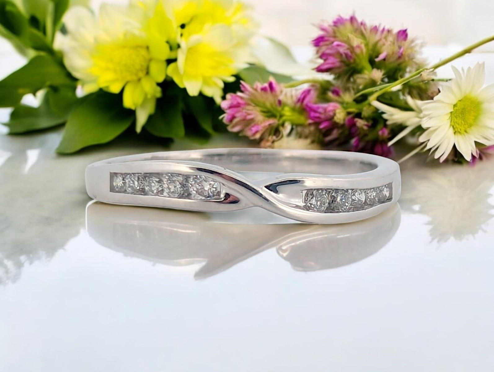 Sleek and contemporary, this 10K white gold band features .18 CTW bezel-set natural diamonds, offering a clean and modern look with added brilliance. The smooth bezel settings provide both elegance and durability, perfect for stacking or wearing