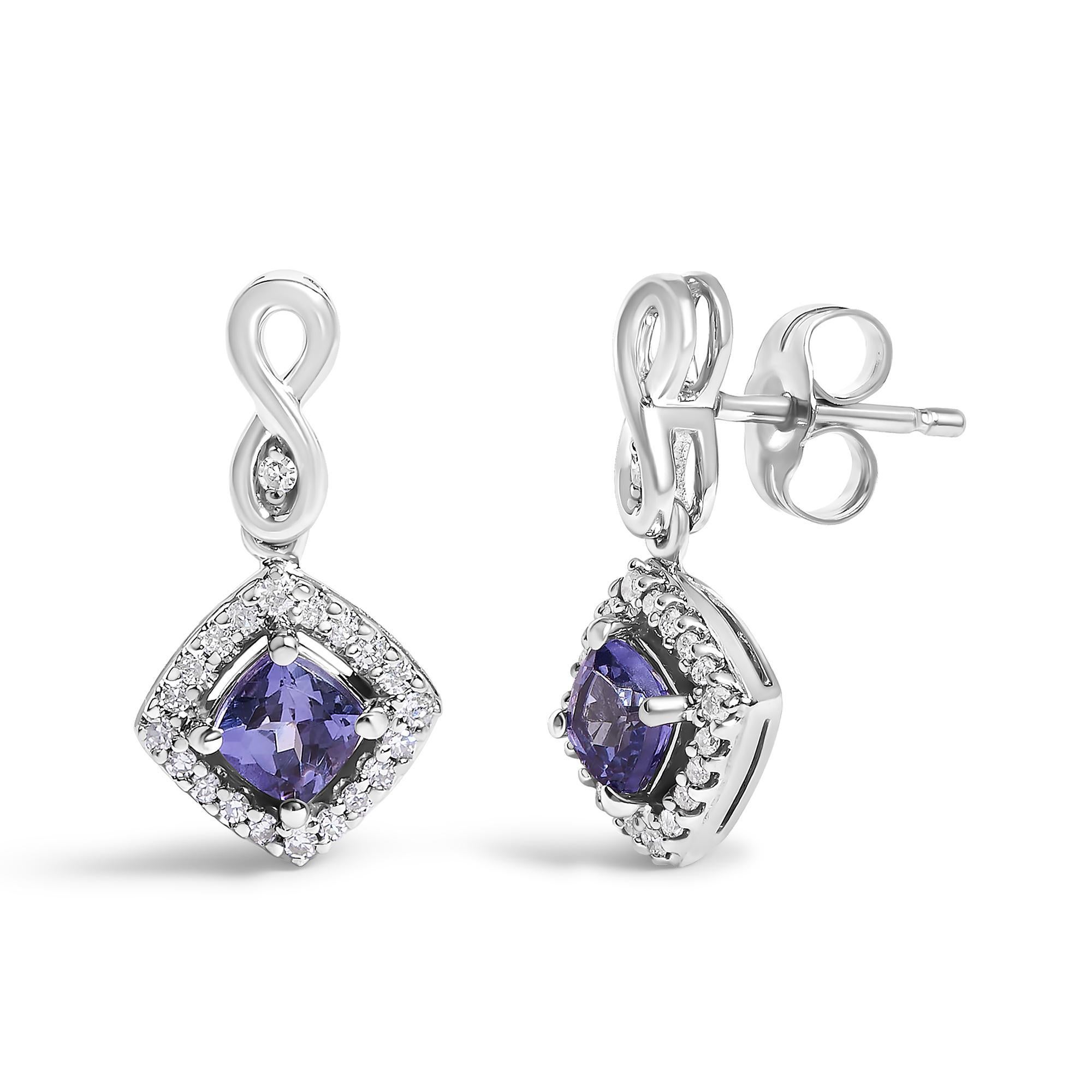Tendi le tue orecchie con lo scintillio celestiale dei nostri squisiti orecchini, ognuno dei quali è caratterizzato da una tanzanite con taglio a cuscino e trattata termicamente che incanta con la sua profonda lucentezza blu-violacea. Incastonate in