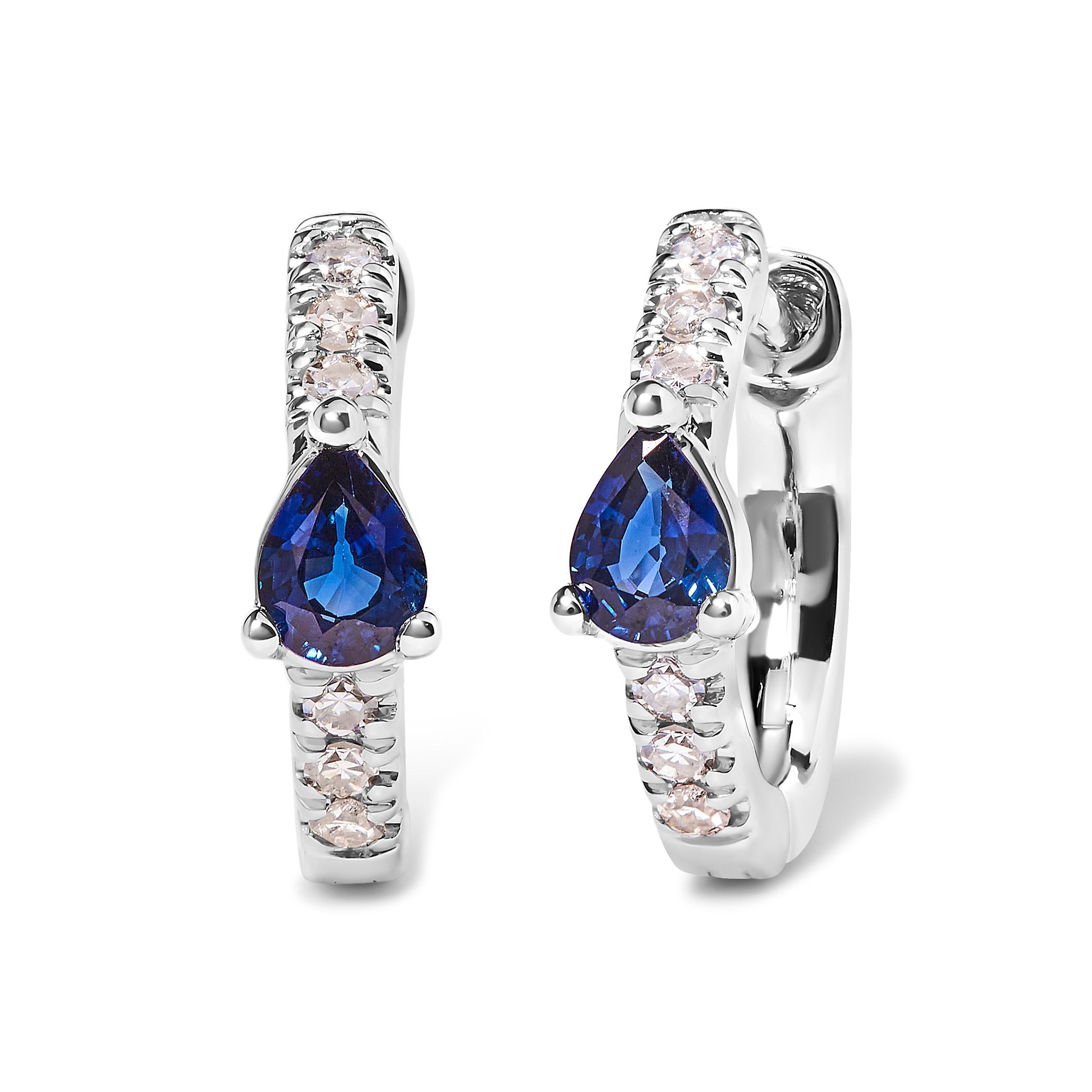 Indulge in the captivating allure of these exquisite 10K White Gold Huggy Hoop Earrings. Crafted with precision, these earrings feature a pear-shaped blue sapphire, radiating its mesmerizing hue. Adorned with a total of 12 dazzling round diamonds,