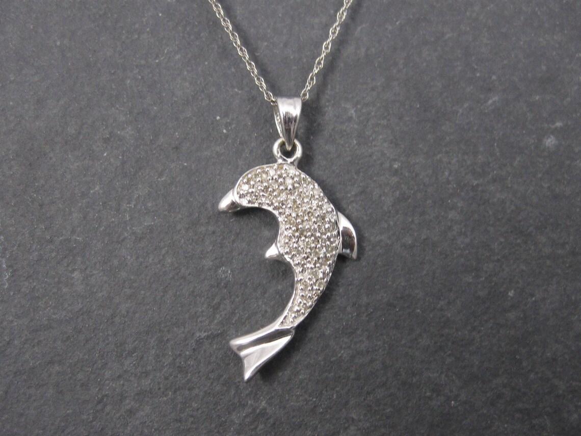 This beautiful dolphin pendant is 10k white gold.
It features an estimated .10 carats in small diamonds.

Measurements: 9/16 by 7/8 of an inch
10K white gold chain is 19 inches from end to end.

Condition: Excellent

