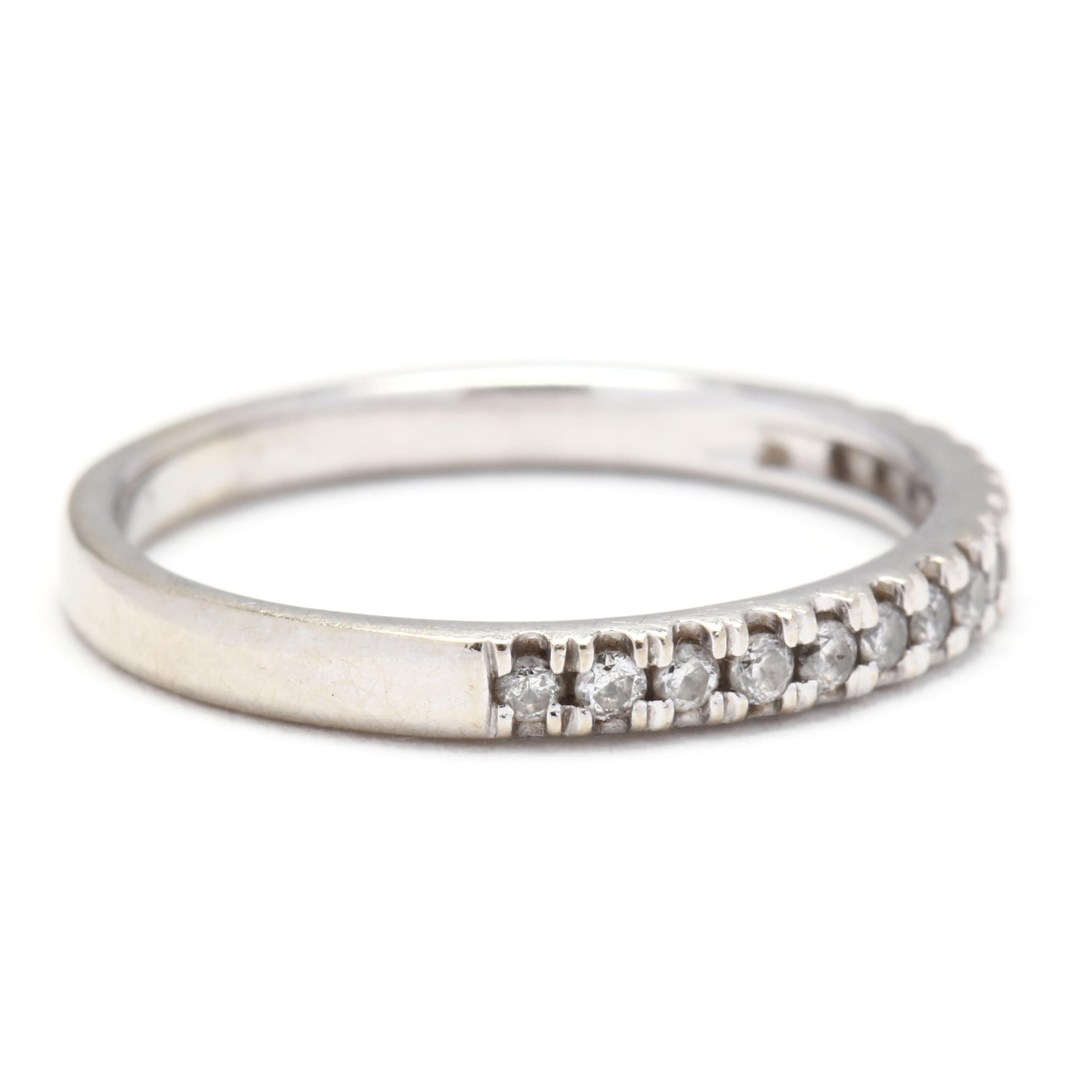 A 10 karat white gold and diamond stackable band ring. This ring features a single row of french set, full cut round diamonds weighing approximately .18 total carats and a thin shank.

Stones:
- diamonds
- full cut round, 15 stones
- 1.4 mm
-